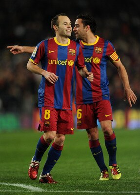 BARCELONA, SPAIN - JANUARY 22:  Andres Iniesta (L) of Barcelona runs past his teammate Xavi Hernandez after scoring his sides third goal during the la liga match between Barcelona and Racing Santander at the Camp Nou stadium on January 22, 2011 in Barcelo