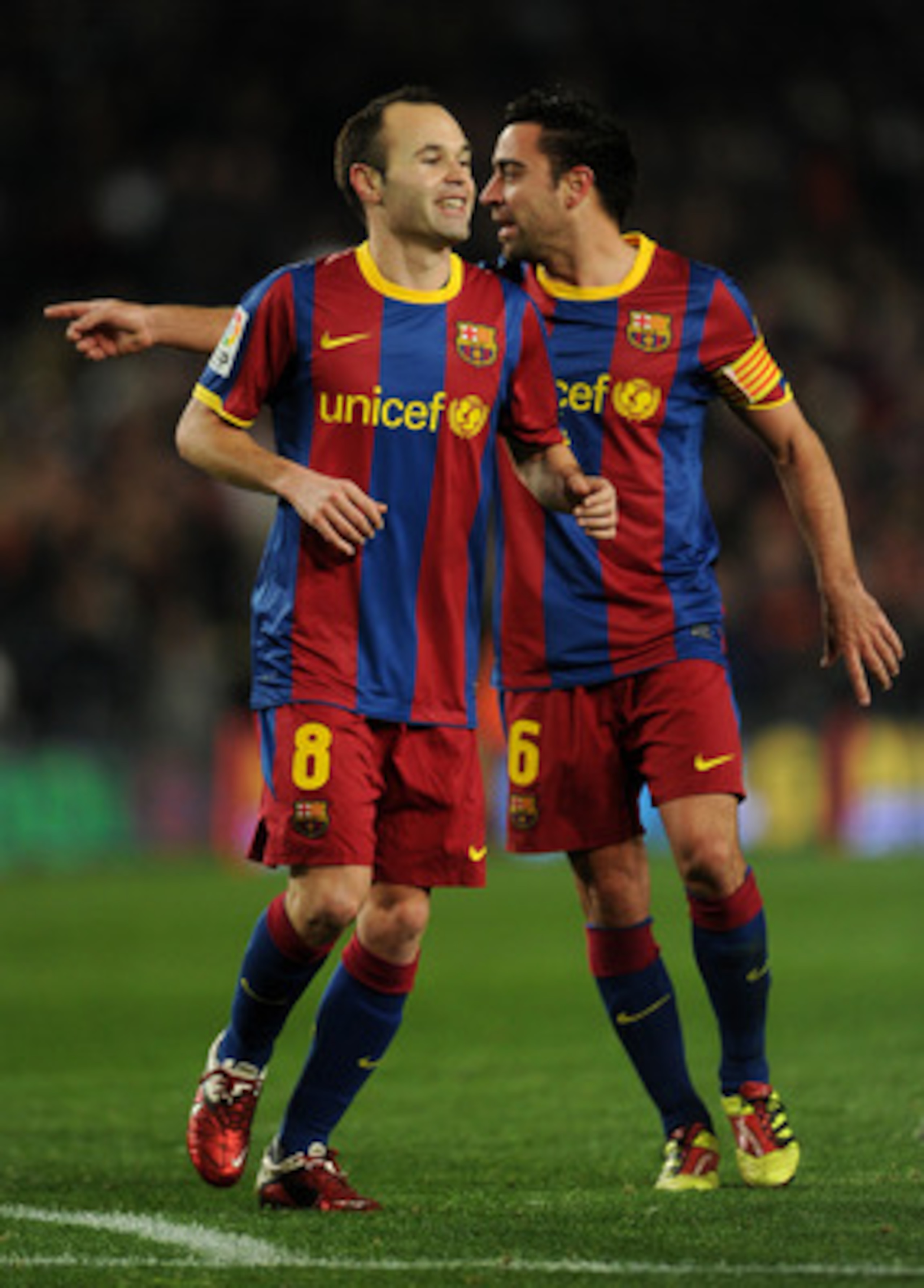 BARCELONA, SPAIN - JANUARY 22: Andres Iniesta (L) of Barcelona runs past his teammate Xavi Hernandez after scoring his sides third goal during the la liga match between Barcelona and Racing Santander at the Camp Nou stadium on January 22, 2011 in Barcelo BARCELONA, SPAIN - JANUARY 22: Andres Iniesta (L) of Barcelona runs past his teammate Xavi Hernandez after scoring his sides third goal during the la liga match between Barcelona and Racing Santander at the Camp Nou stadium on January 22, 2011 in Barcelo
