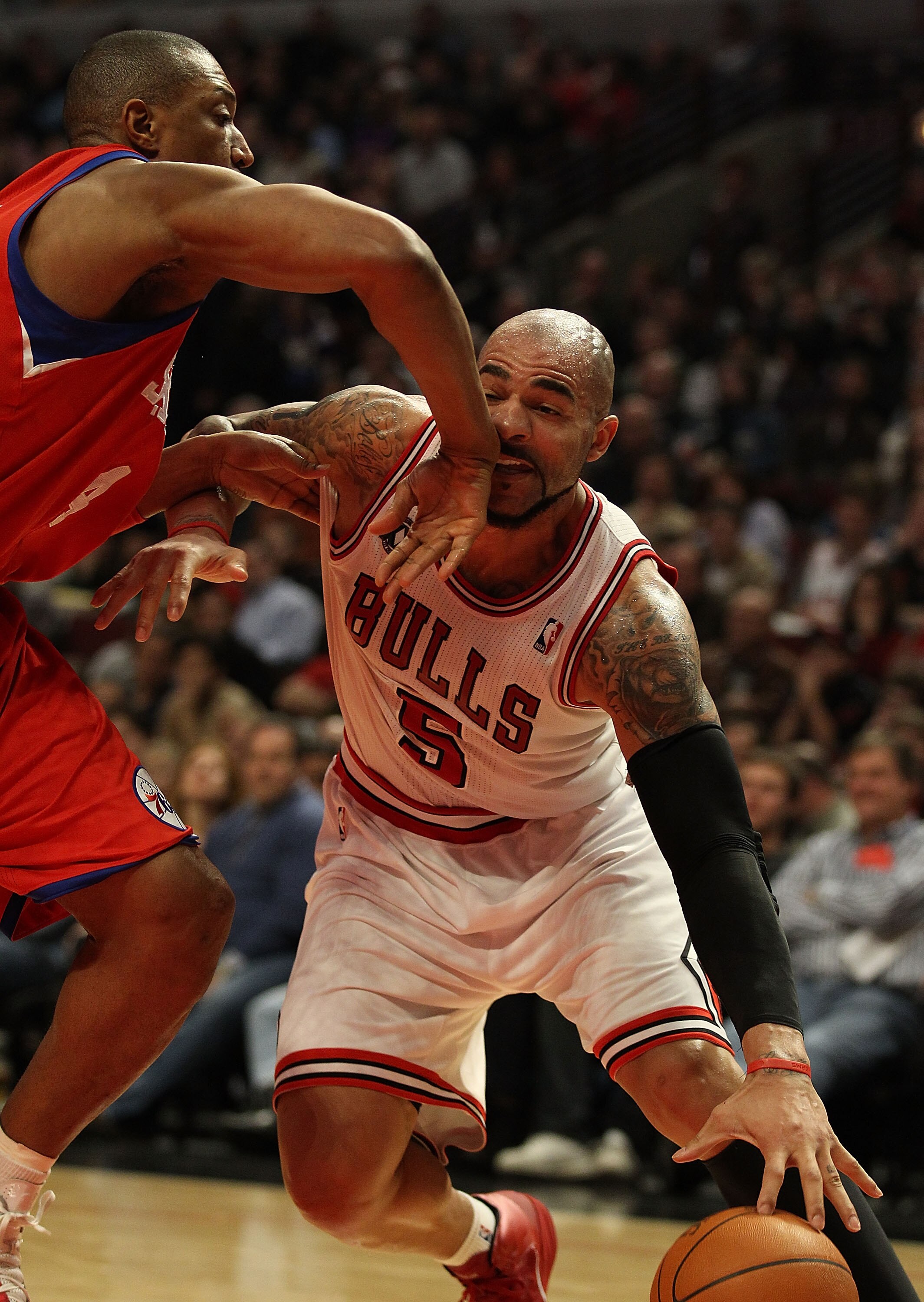 CHICAGO, IL - DECEMBER 21: Carlos Boozer #5 of the Chicago Bulls is hit in the mouth by Tony Battie #4 of the Philadelphia 76ers at the United Center on December 21, 2010 in Chicago, Illinois. The Bulls defeated the 76ers 121-76. NOTE TO USER: User expres