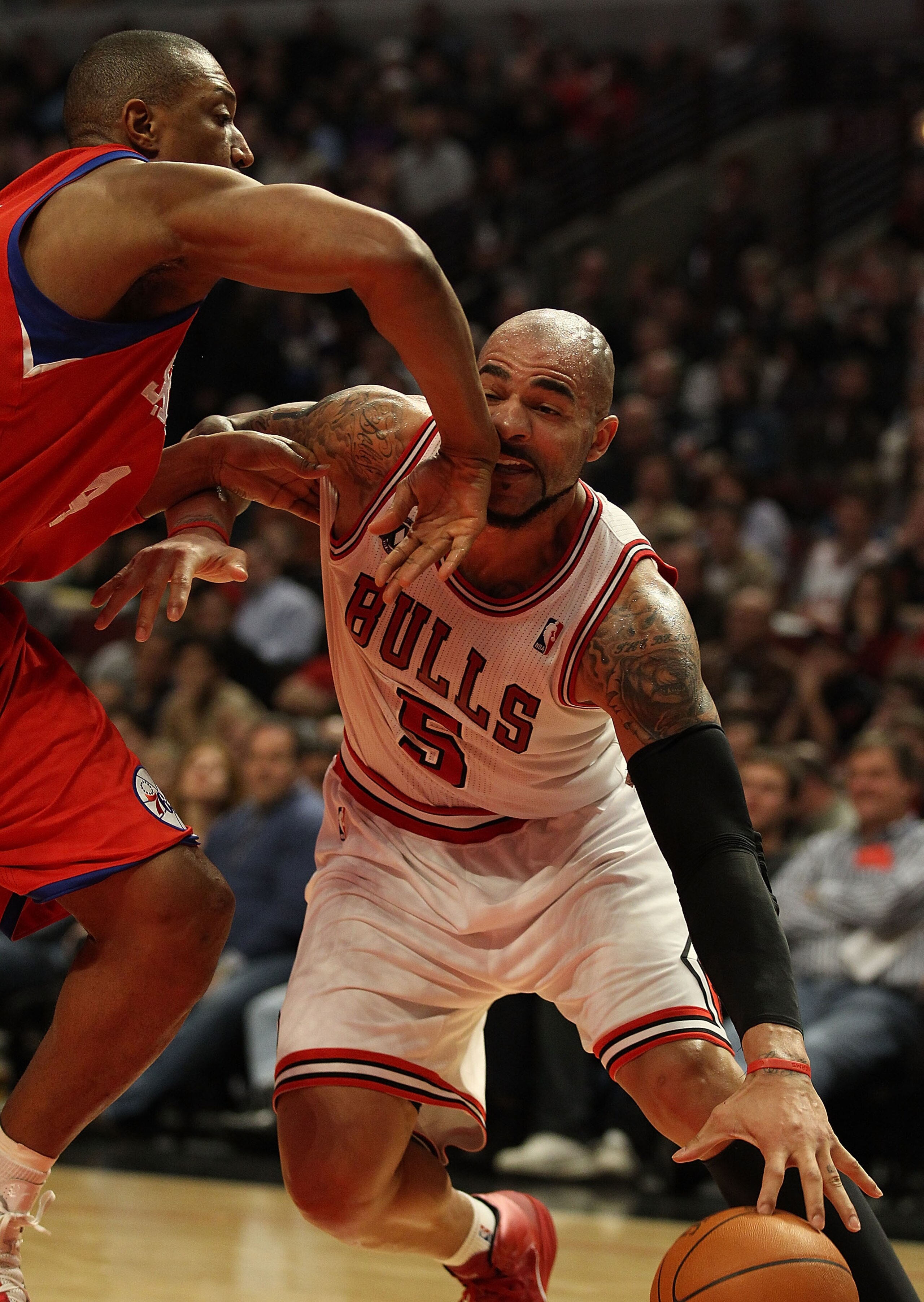 CHICAGO, IL - DECEMBER 21: Carlos Boozer #5 of the Chicago Bulls is hit in the mouth by Tony Battie #4 of the Philadelphia 76ers at the United Center on December 21, 2010 in Chicago, Illinois. The Bulls defeated the 76ers 121-76. NOTE TO USER: User expres