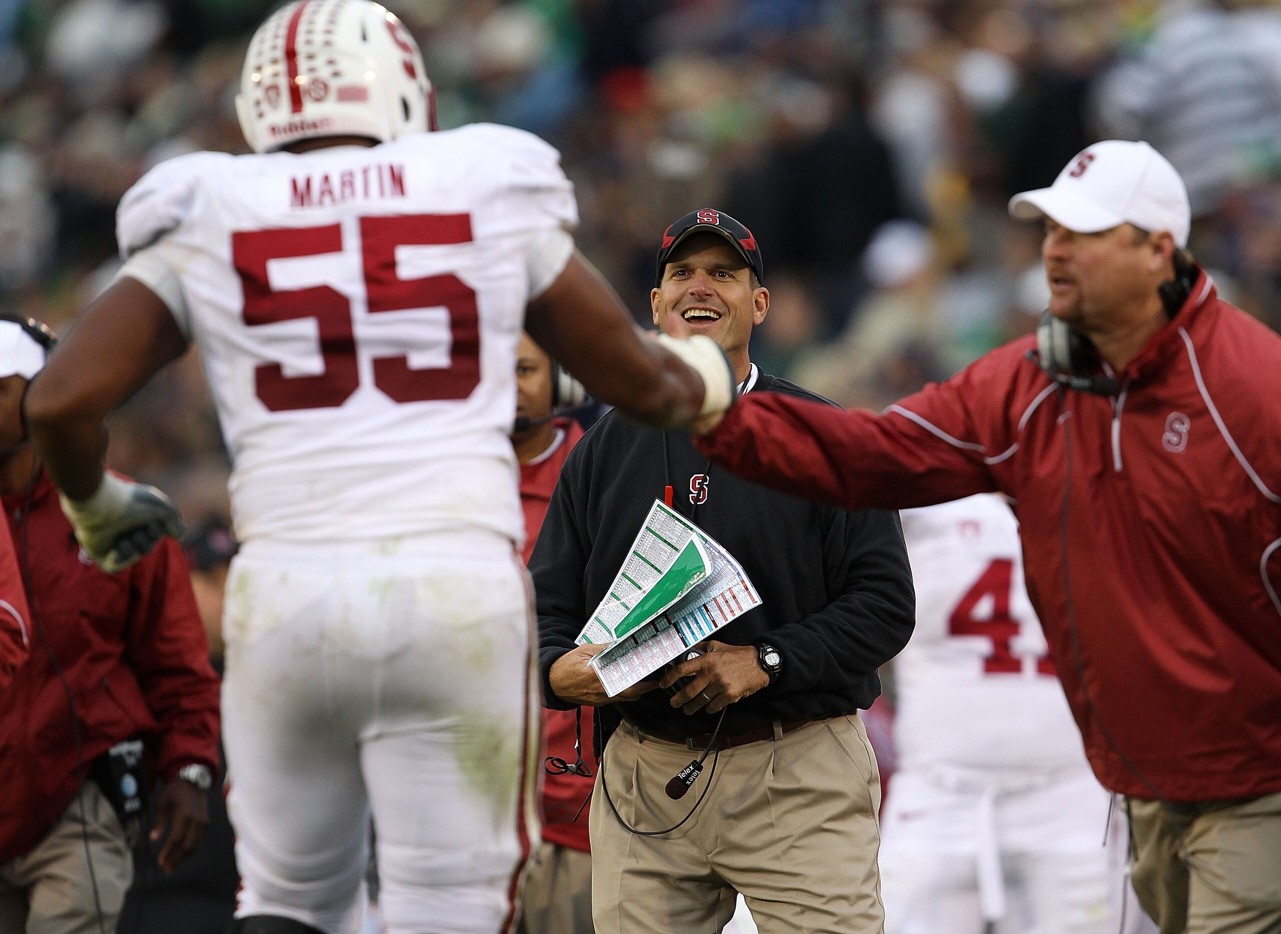 SOUTH BEND, IN - SEPTEMBER 25: Head coach Jim Harbaugh of the Stanford Cardinal smiles at Jonathan Martin #55 after a play against the Notre Dame Fighting Irish at Notre Dame Stadium on September 25, 2010 in South Bend, Indiana. Stanford defeated Notre Da