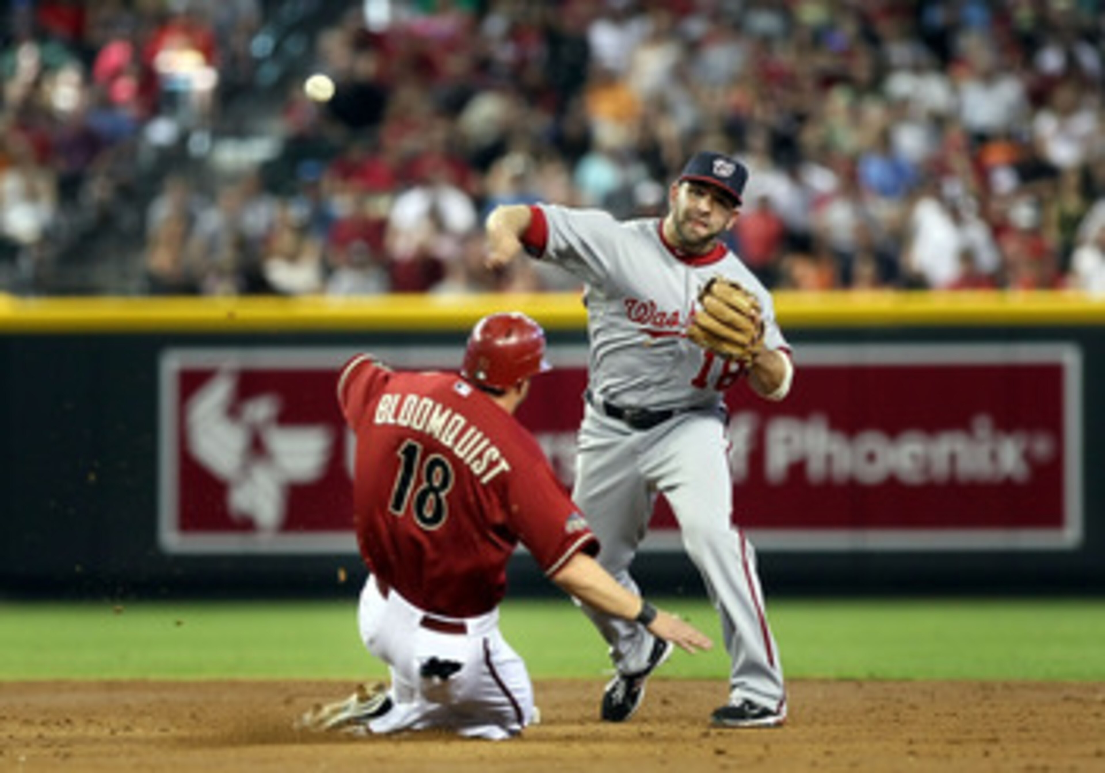 PHOENIX, AZ - JUNE 05:  Infielder Danny Espinosa #18 of the Washington Nationals throws over the sliding Willie Bloomquist #18 of the Arizona Diamondbacks to complete a double play during the thrid inning of the Major League Baseball game at Chase Field o