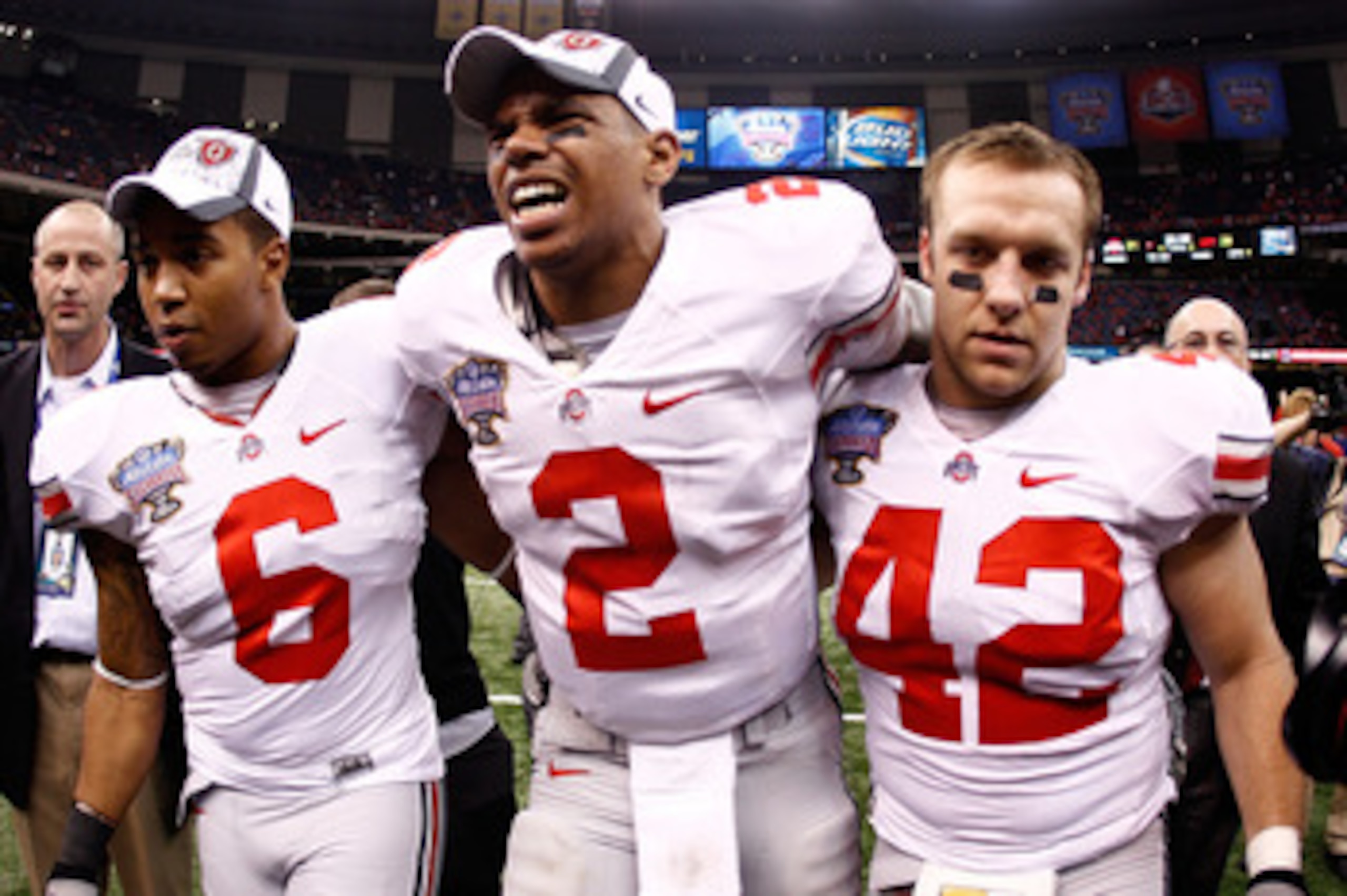 NEW ORLEANS, LA - JANUARY 04:  (M) Quarterback Terrelle Pryor #2 of the Ohio State Buckeyes is helped off the field by teammates Etienne Sabino #6 and Andrew Sweat #42 after the Buckeyes 31-26 victory against the Arkansas Razorbacks during the Allstate Su