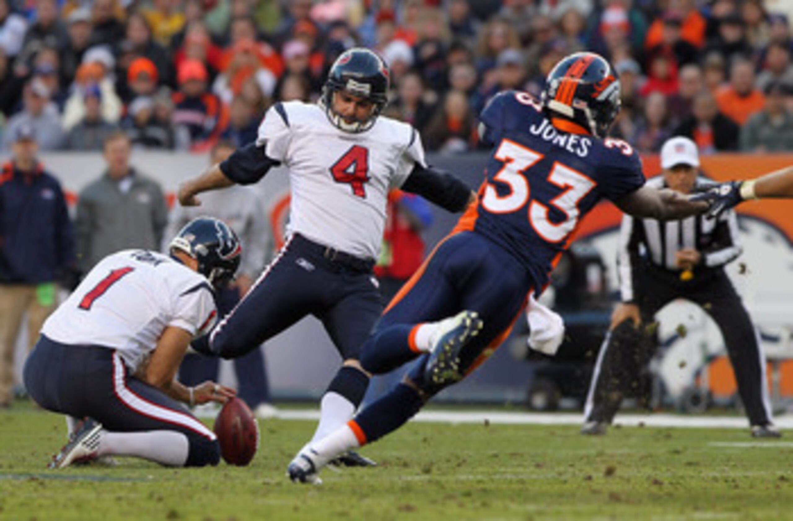 DENVER - DECEMBER 26:  Place kicker Neil Rackers #4 of the Houston Texas kicks a 57 yard field goal from the hold of Matt Turk #1 as Nate Jones #33 of the Denver Broncos looks to block the third quarter kick at INVESCO Field at Mile High on December 26, 2