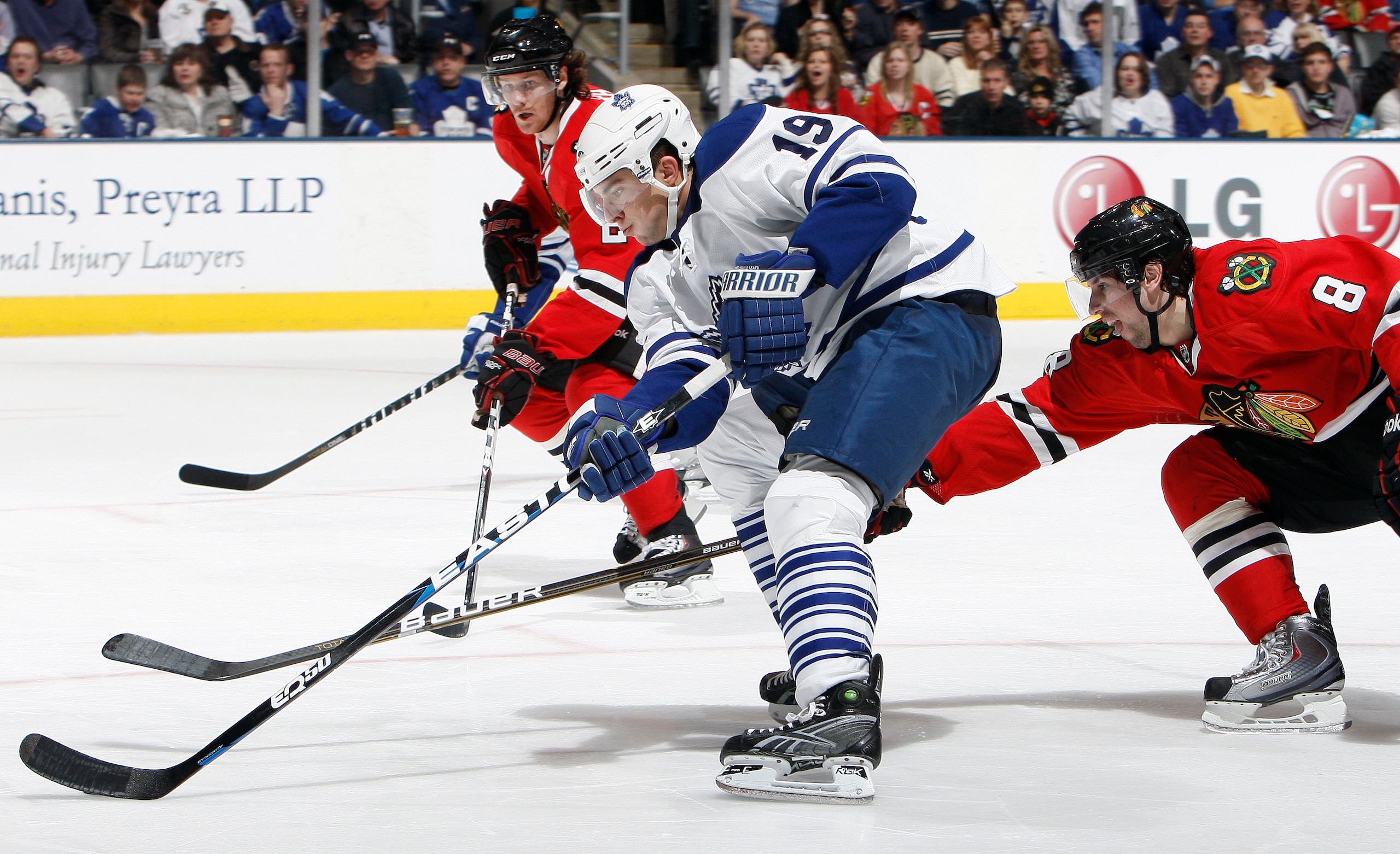 TORONTO, CANADA - MARCH 5: Joffrey Lupul #19 of the Toronto Maple Leafs drives the net on Nick Leddy #8 and Duncan Keith #2 of the Chicago Blackhawks during game action at the Air Canada Centre March 5, 2011 in Toronto, Ontario, Canada. (Photo by Abelimag