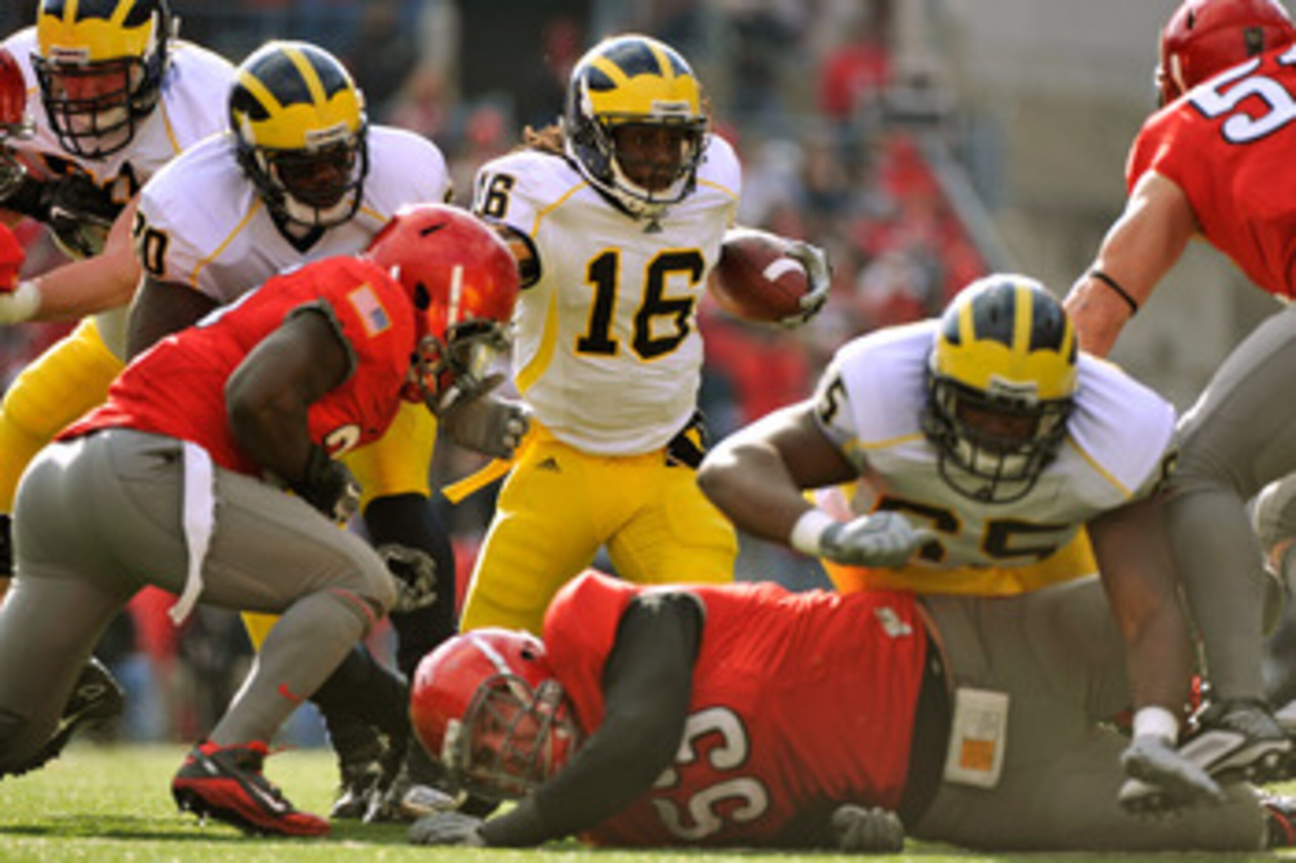 COLUMBUS, OH - NOVEMBER 27:  Quarterback Denard Robinson #16 of the Michigan Wolverines looks for running room against the Ohio State Buckeyes at Ohio Stadium on November 27, 2010 in Columbus, Ohio.  (Photo by Jamie Sabau/Getty Images)