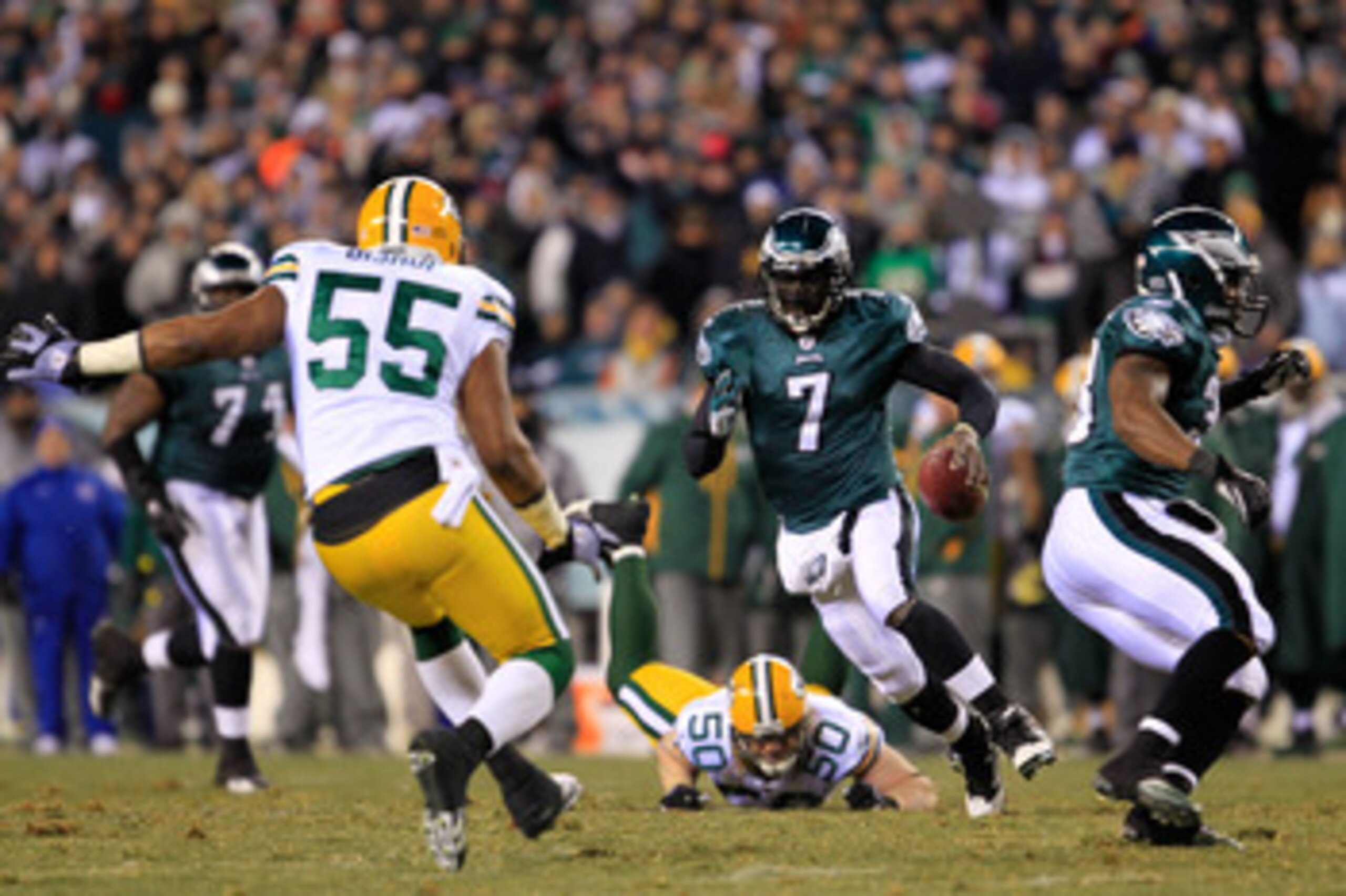 PHILADELPHIA, PA - JANUARY 09:  Michael Vick #7 of the Philadelphia Eagles scrambles against A.J. Hawk #50 and Desmond Bishop #55 of the Green Bay Packers during the 2011 NFC wild card playoff game at Lincoln Financial Field on January 9, 2011 in Philadel