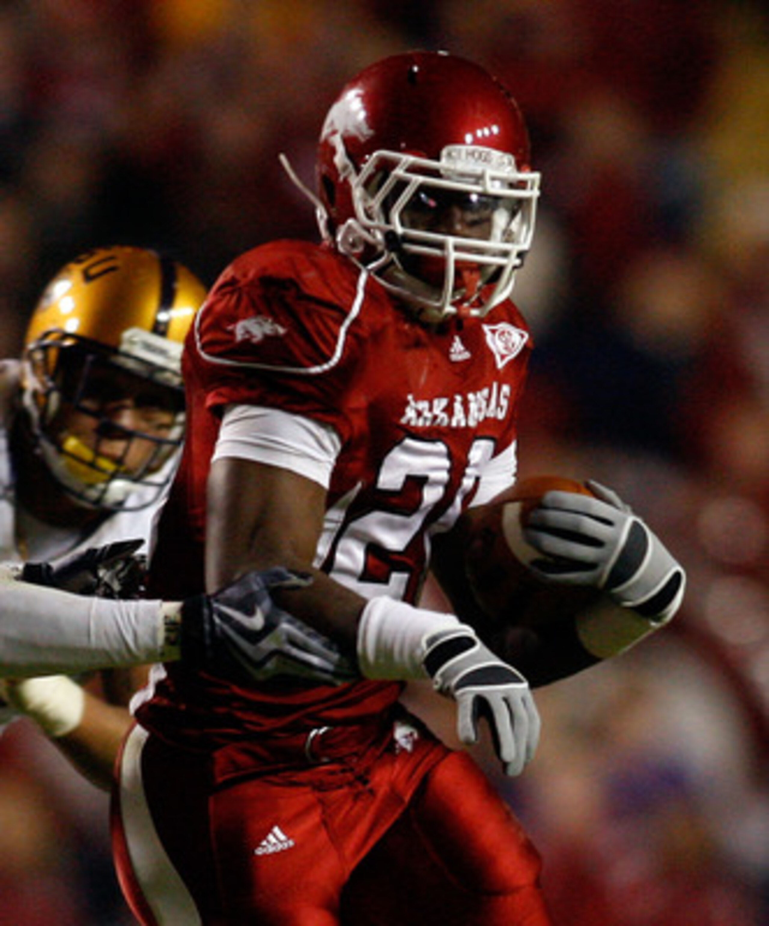BATON ROUGE, LA - NOVEMBER 28:  Ronnie Wingo Jr. #20 of the Arkansas Razorbacks avoids a tackle by Harry Coleman #24 and Rahim Alem #84 of the LSU Tigers at Tiger Stadium on November 28, 2009 in Baton Rouge, Louisiana.  The Tigers defeated the Razorbacks