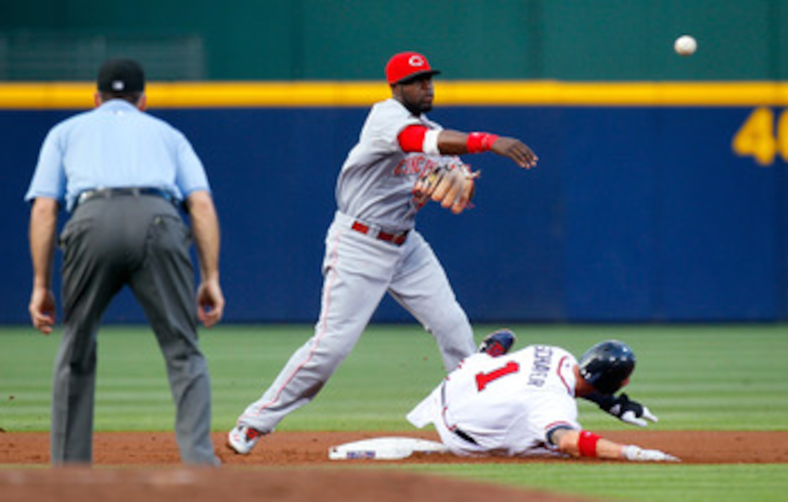 ATLANTA, GA - MAY 27:  Brandon Phillips #4 of the Cincinnati Reds turns a double play over Jordan Schafer #1 of the Atlanta Braves in the first inning at Turner Field on May 27, 2011 in Atlanta, Georgia.  (Photo by Kevin C. Cox/Getty Images)
