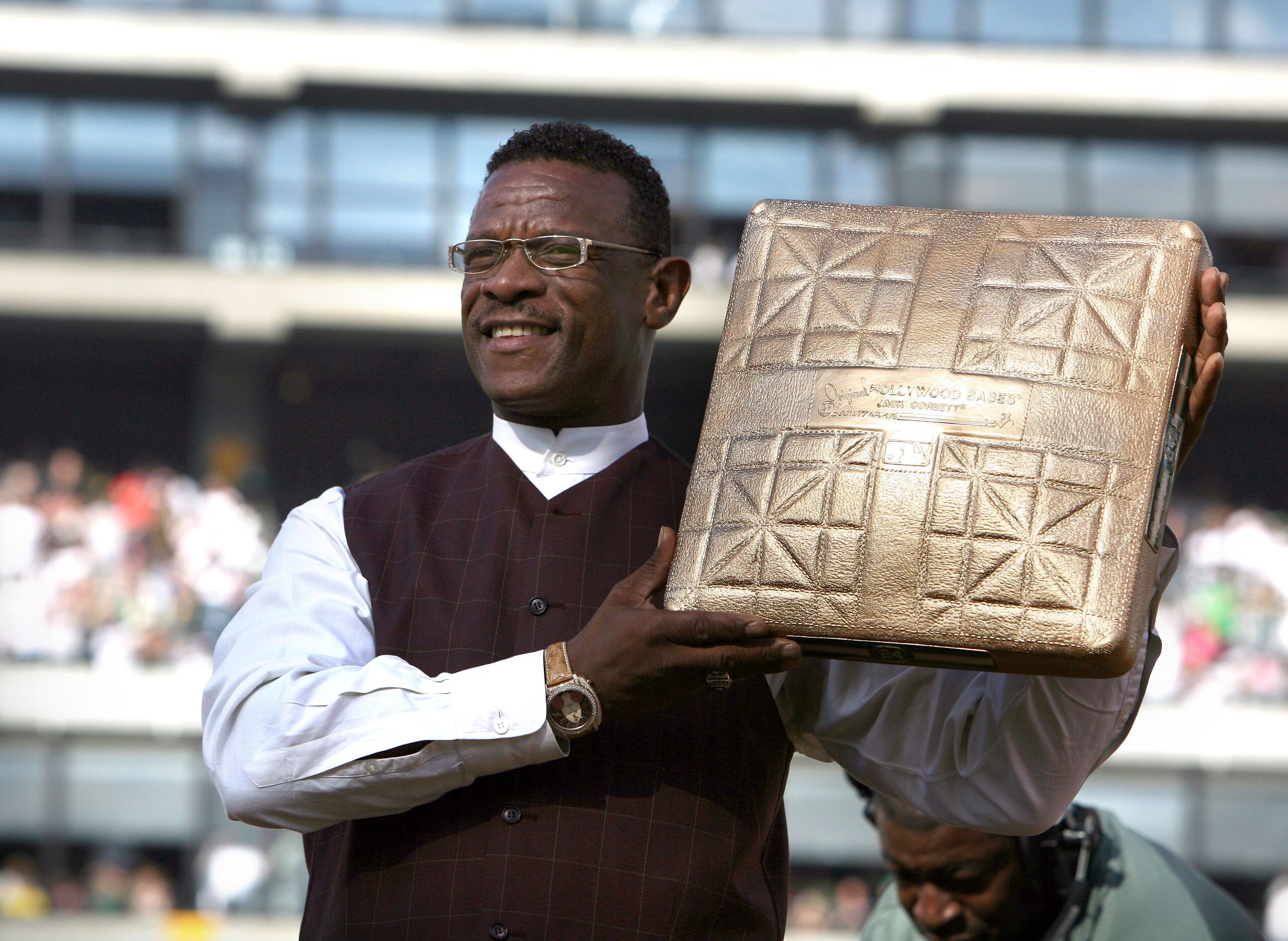 OAKLAND, CA - AUGUST 01:  Hall of Fame baseball player Rickey Henderson holds up a golden base during a ceremony to retire his number 24 by the Oakland Athletics before the start of the game against the Toronto Blue Jays August 1, 2009 at the McAfee Colis