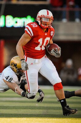LINCOLN, NE - NOVEMBER 26: Roy Helu Jr. #10 of the Nebraska Cornhuskers runs past Liloa Nobriga #48 of the Colorado Buffaloes during the first half of their game at Memorial Stadium on November 26, 2010 in Lincoln, Nebraska. Nebraska defeated Colorado 45-