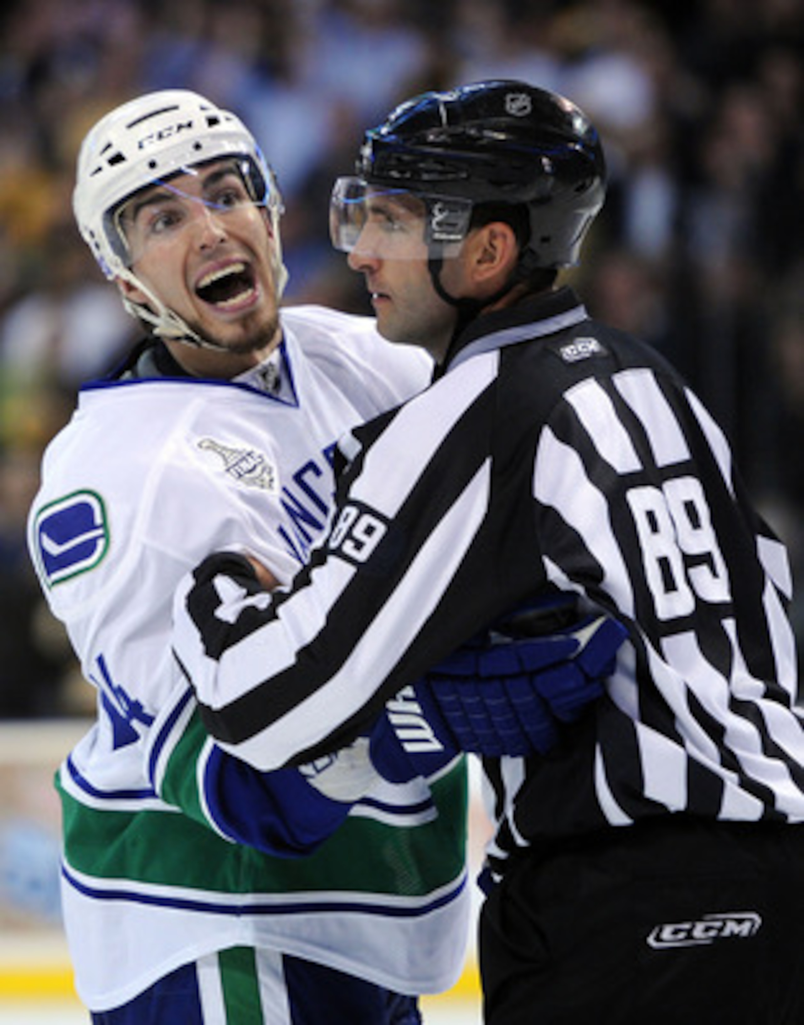 BOSTON, MA - JUNE 06:  Alex Burrows #14 of the Vancouver Canucks gets held back by linesman Steve Miller #89 after a play against the Boston Bruins in Game Three of the 2011 NHL Stanley Cup Final at TD Garden on June 6, 2011 in Boston, Massachusetts.  (Ph