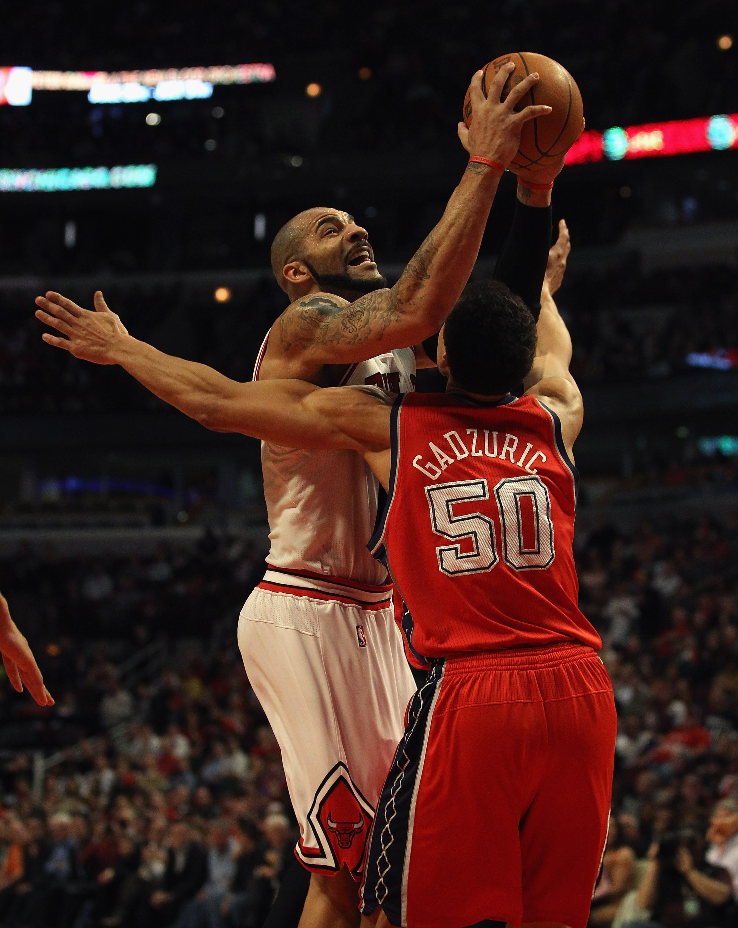 CHICAGO, IL - APRIL 13: Carlos Boozer #5 of the Chicago Bulls drives against Dan Gadzuric #50 of the New Jersey Nets at the United Center on April 13, 2011 in Chicago, Illinois. The Bulls defeated the Nets 97-92. NOTE TO USER: User expressly acknowledges