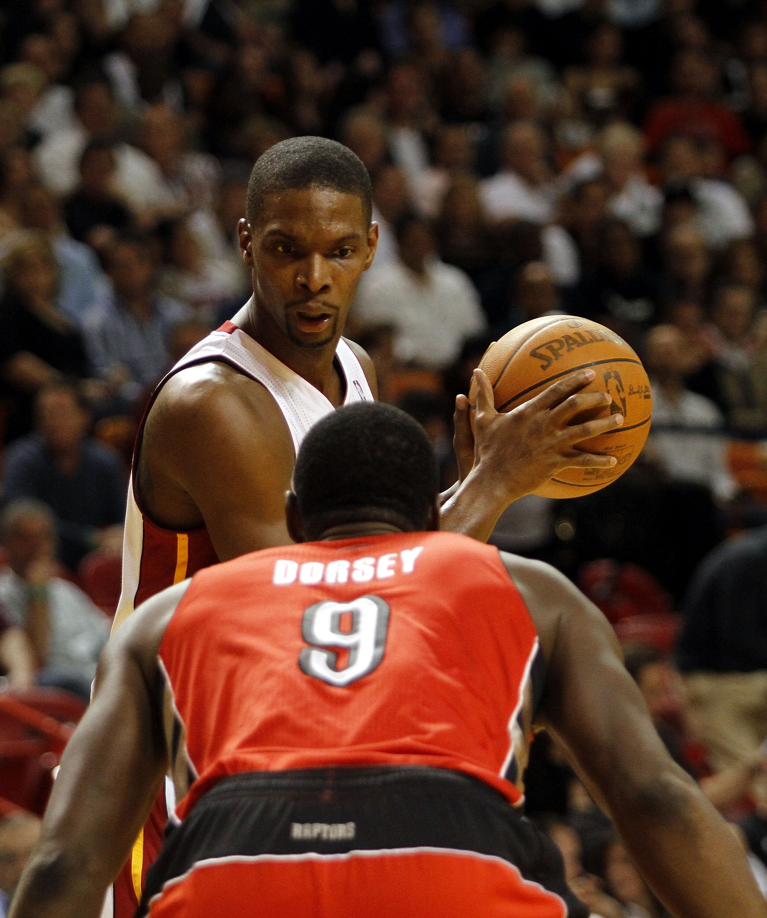 MIAMI - NOVEMBER 13:  Forward Chris Bosh #1 of the Miami Heat against Joey Dorsey #9 of the Toronto Raptors at American Airlines Arena on November 13, 2010 in Miami, Florida. NOTE TO USER: User expressly acknowledges and agrees that, by downloading and or