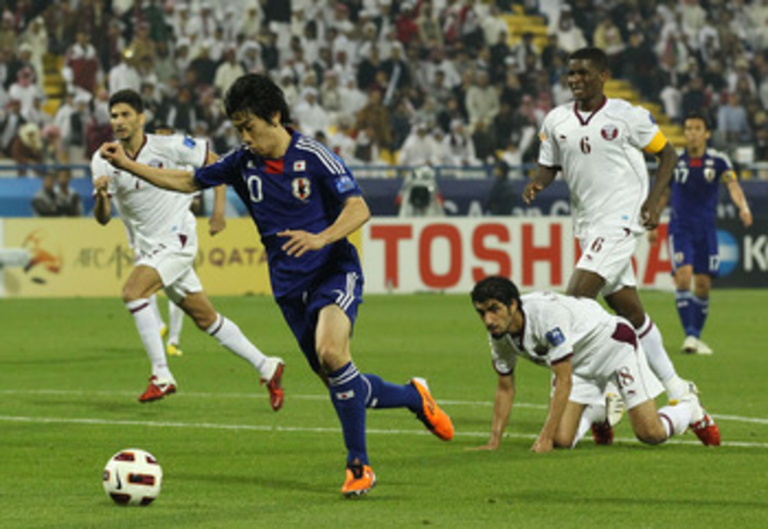 DOHA, QATAR - JANUARY 21:  Shinji Kagawa #10 of Japan gets away from his opponents to score during the AFC Asian Cup quarter final match between Japan and Qatar at Al-Gharafa Stadium on January 21, 2011 in Doha, Qatar.  (Photo by Robert Cianflone/Getty Im