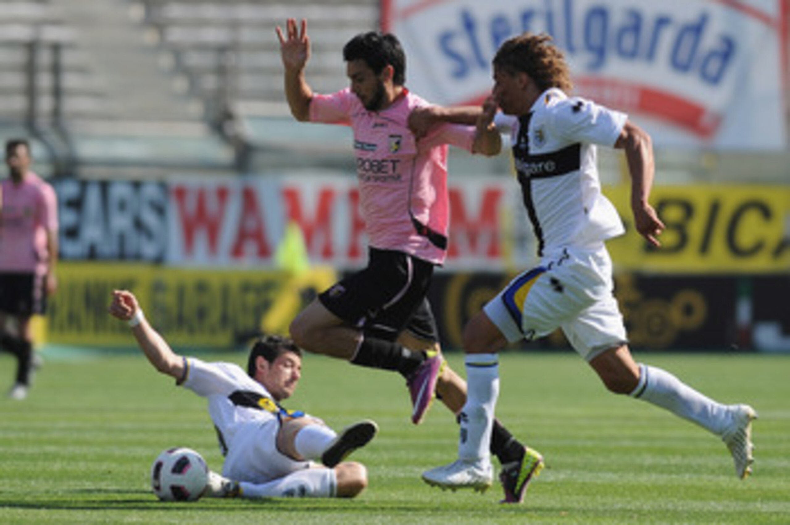 PARMA, ITALY - MAY 01:   Javier Matias Pastore of US Citta di Palermo is challenged by Blerin Dzemaili (L) and Rolf Gunther Feltscher Martinez (R) of Parma FCduring the Serie A match between Parma FC and US Citta di Palermo at Stadio Ennio Tardini on May 