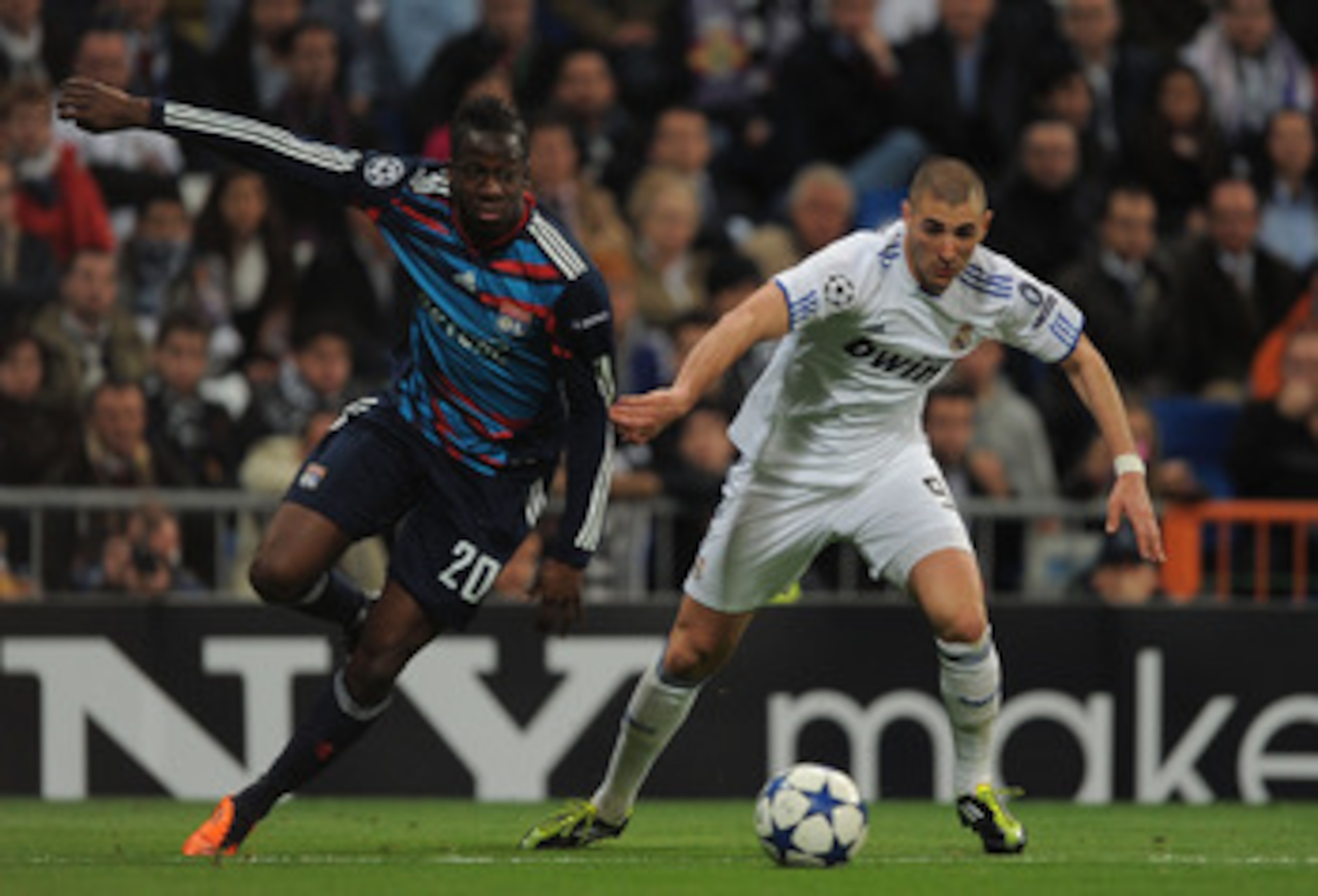 MADRID, SPAIN - MARCH 16: Karim Benzema (R) of Real Madrid gets past Aly Cissokho of Lyon during the UEFA Champions League round of 16 second leg match between Real Madrid and Lyon at Estadio Santiago Bernabeu on March 16, 2011 in Madrid, Spain.  (Photo b