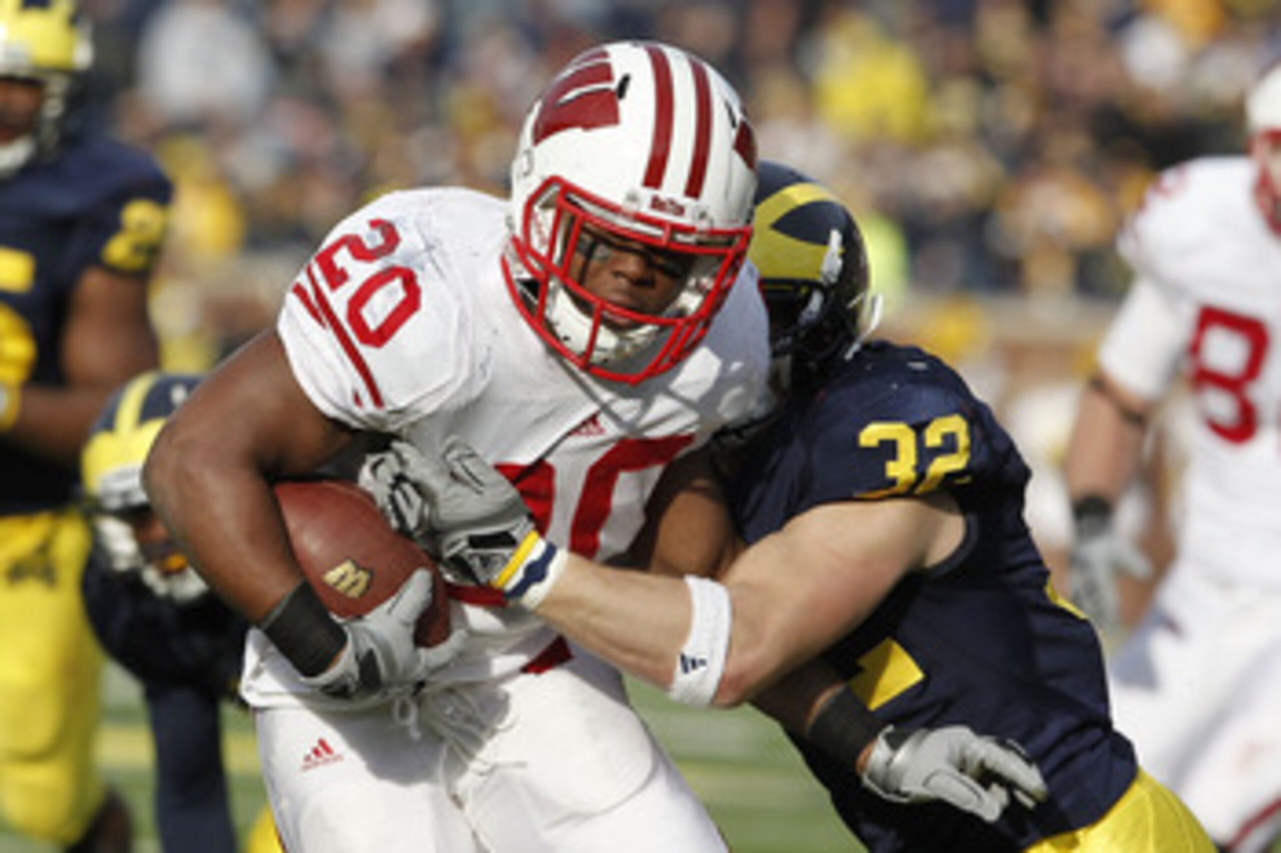 ANN ARBOR, MI - NOVEMBER 20:  James White #20 of the Wisconsin Badgers treies to get around the tackle of Jordan Kovacs #32 of the Michigan Wolverines at Michigan Stadium on November 20, 2010 in Ann Arbor, Michigan. Wisconson won the game 48-28.  (Photo b