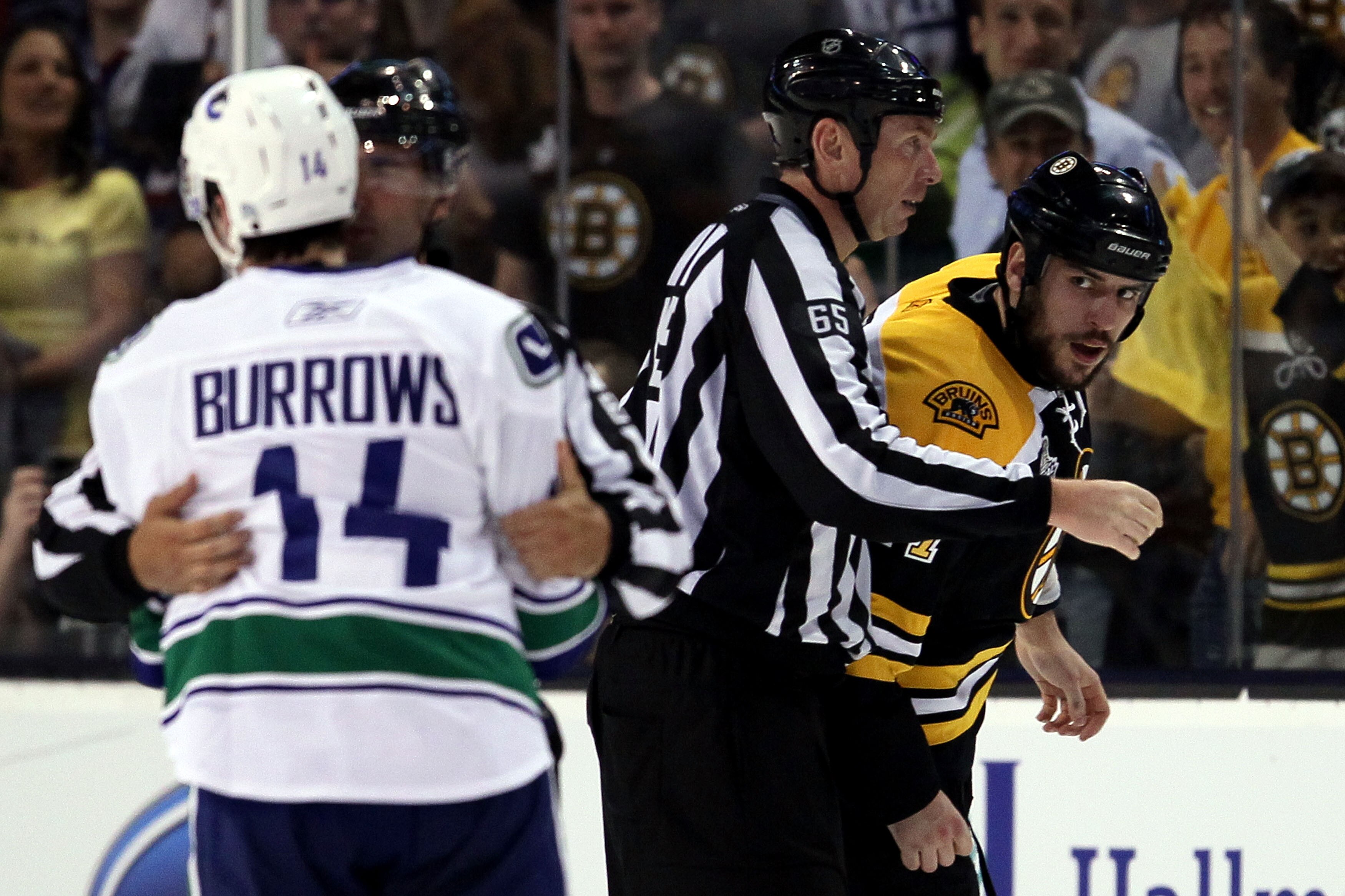 BOSTON, MA - JUNE 06:  Linesman Pierre Racicot #65 breaks up a fight between Milan Lucic #17 of the Boston Bruins and Alex Burrows #14 of the Vancouver Canucks during Game Three of the 2011 NHL Stanley Cup Final at TD Garden on June 6, 2011 in Boston, Mas