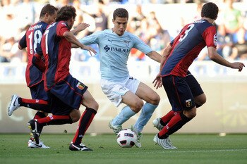 ROME, ITALY - MAY 14:  Anderson Hernanes of SS Lazio in action against Rafinha Ferreira (L), Marco Rossi (C) and Dario Dainelli (R) of Genoa CFC during the Serie A match between SS Lazio and Genoa CFC at Stadio Olimpico on May 14, 2011 in Rome, Italy.  (P