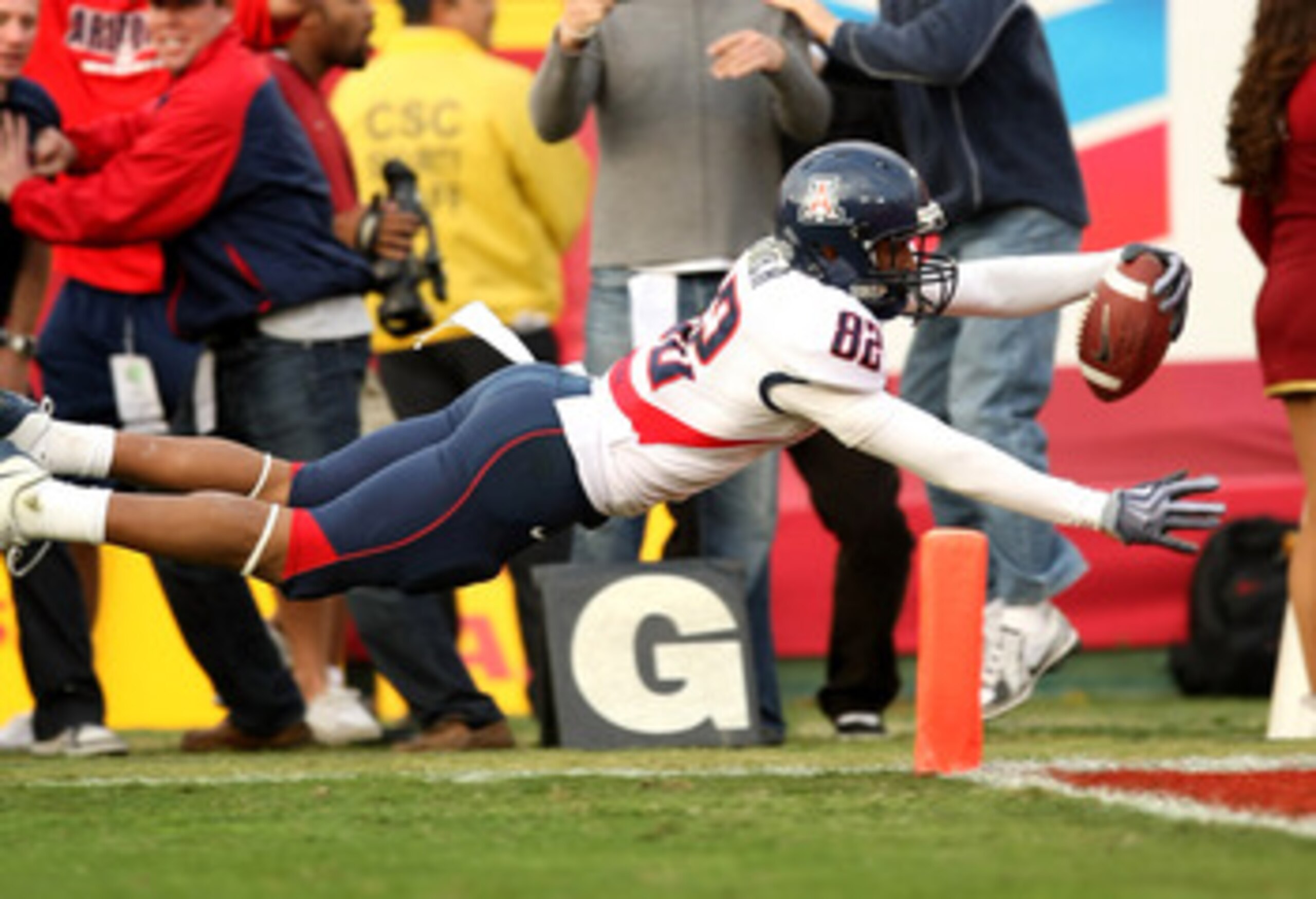 LOS ANGELES, CA - DECEMBER 05:  Wide receiver Juron Criner #82 of the Arizona Wildcats dives into the end zone with  a 36 yard catch for the winning touchdown in the fourth quarter against the USC Trojans on December 5, 2009 at the Los Angeles Coliseum in