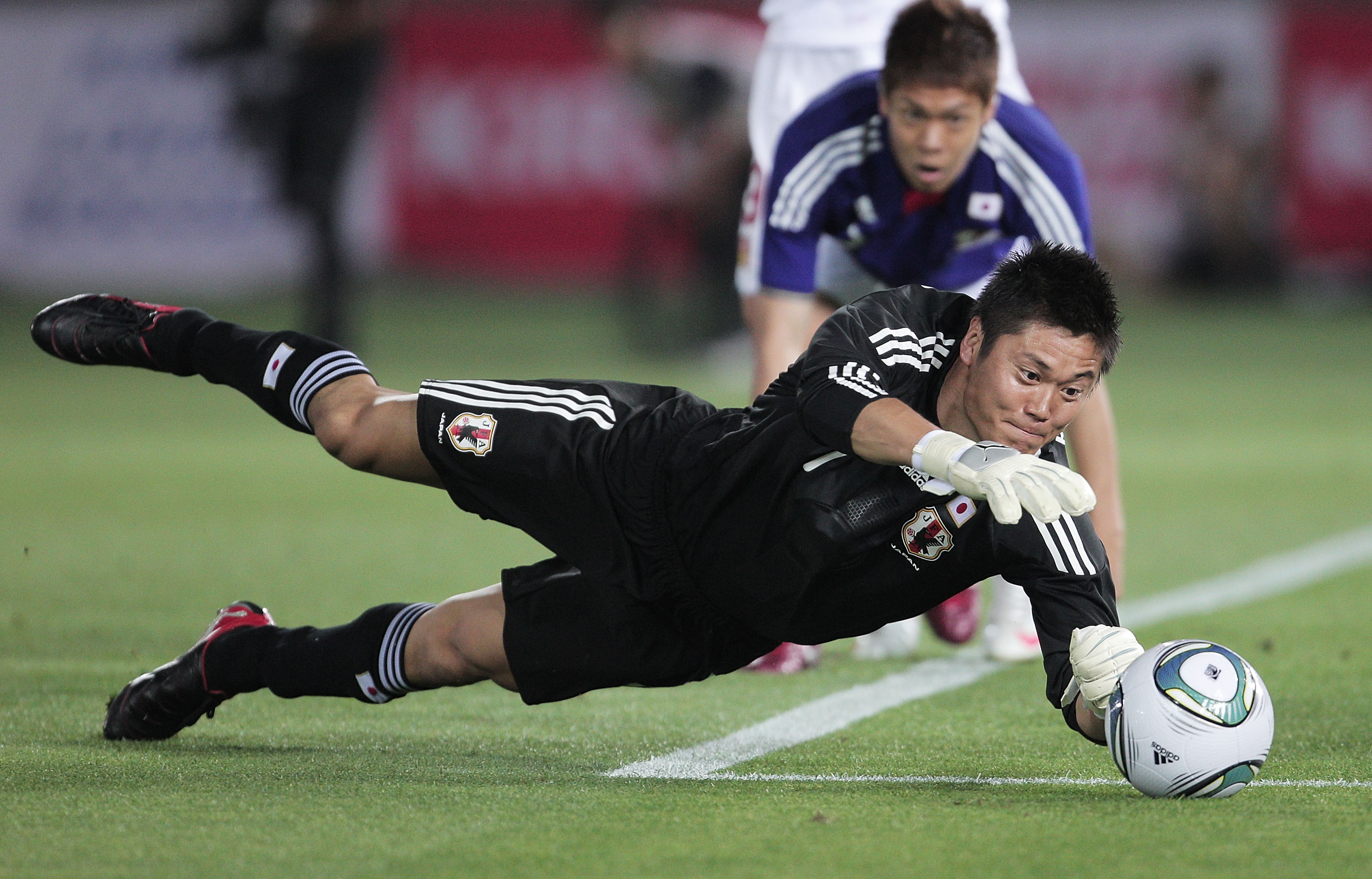 YOKOHAMA, JAPAN - JUNE 07:  Eiji Kawashima of Japan dives for  save during the Kirin Cup Soccer match between Japan and the Czech Republic held at Nissan Stadium on June 7, 2011 in Yokohama, Japan.  (Photo by Adam Pretty/Getty Images)