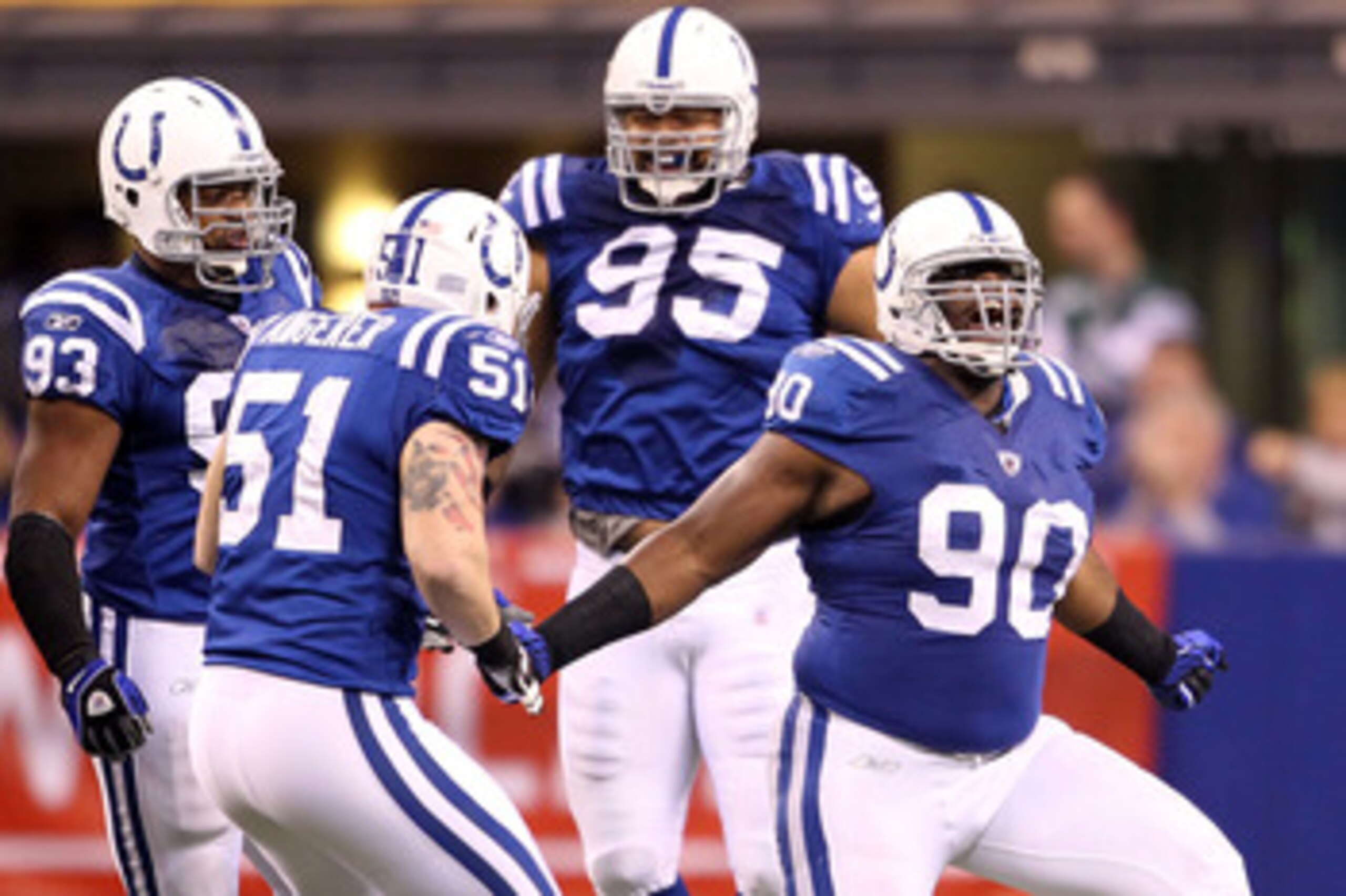 INDIANAPOLIS, IN - JANUARY 08:  Dan Muir #90 of the Indianapolis Colts celebrates with Dwight Freeney #93, Pat Angerer #51 and Fili Moala #95 after he sacked quarterback Mark Sanchez #6 of the New York Jets in the first quarter during their 2011 AFC wild 