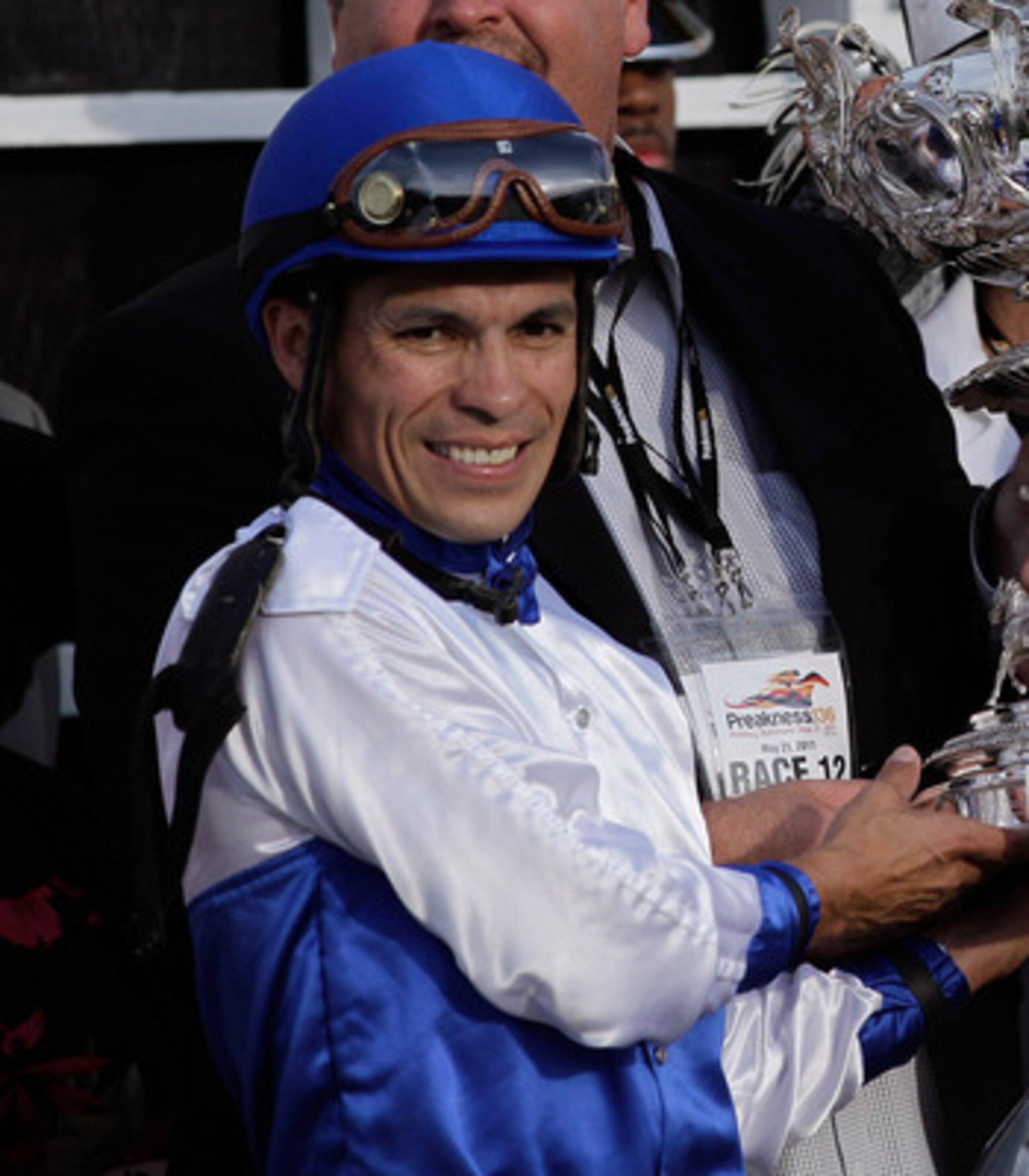 BALTIMORE, MD - MAY 21:  Jockey Jesus Castanon (L) along with trainer Mike Romans, and co-owners Mike Lauffer, and Bill Cubbedge (R) celebrate with the trophy in the winners circle after their horse Shackleford #5 won the 136th running of the Preakness St