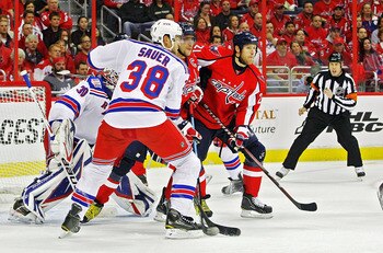 WASHINGTON , DC - APRIL 23: Brooks Laich #21 and Alex Ovechkin #8 of the Washington Capitals battle in the crease against Michael Sauer #38 and Henrik Lundqvist #30 of the New York Rangers in Game Five of the Eastern Conference Quarterfinals during the 20