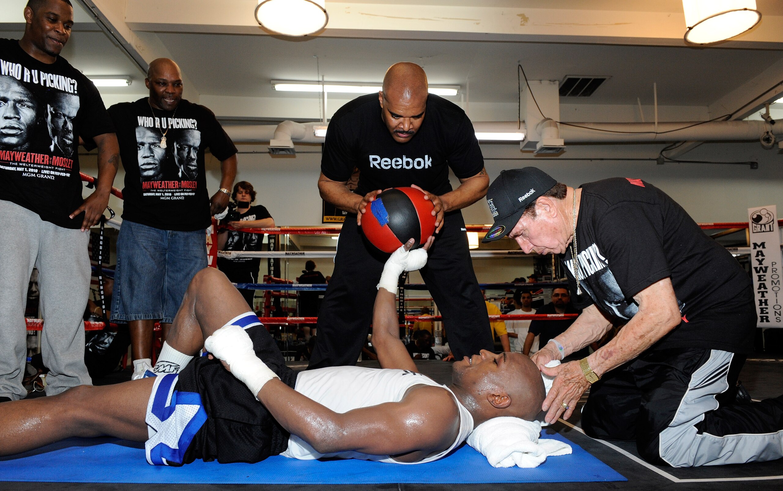 LAS VEGAS - APRIL 14:  Boxer Floyd Mayweather Jr. works out with help from (L-R) camp coordinator DeJuan Blake, massage therapist John Sinclair, Mayweather Promotions CEO Leonard Ellerbe and cornerman Rafael Garcia April 14, 2010 in Las Vegas, Nevada. May