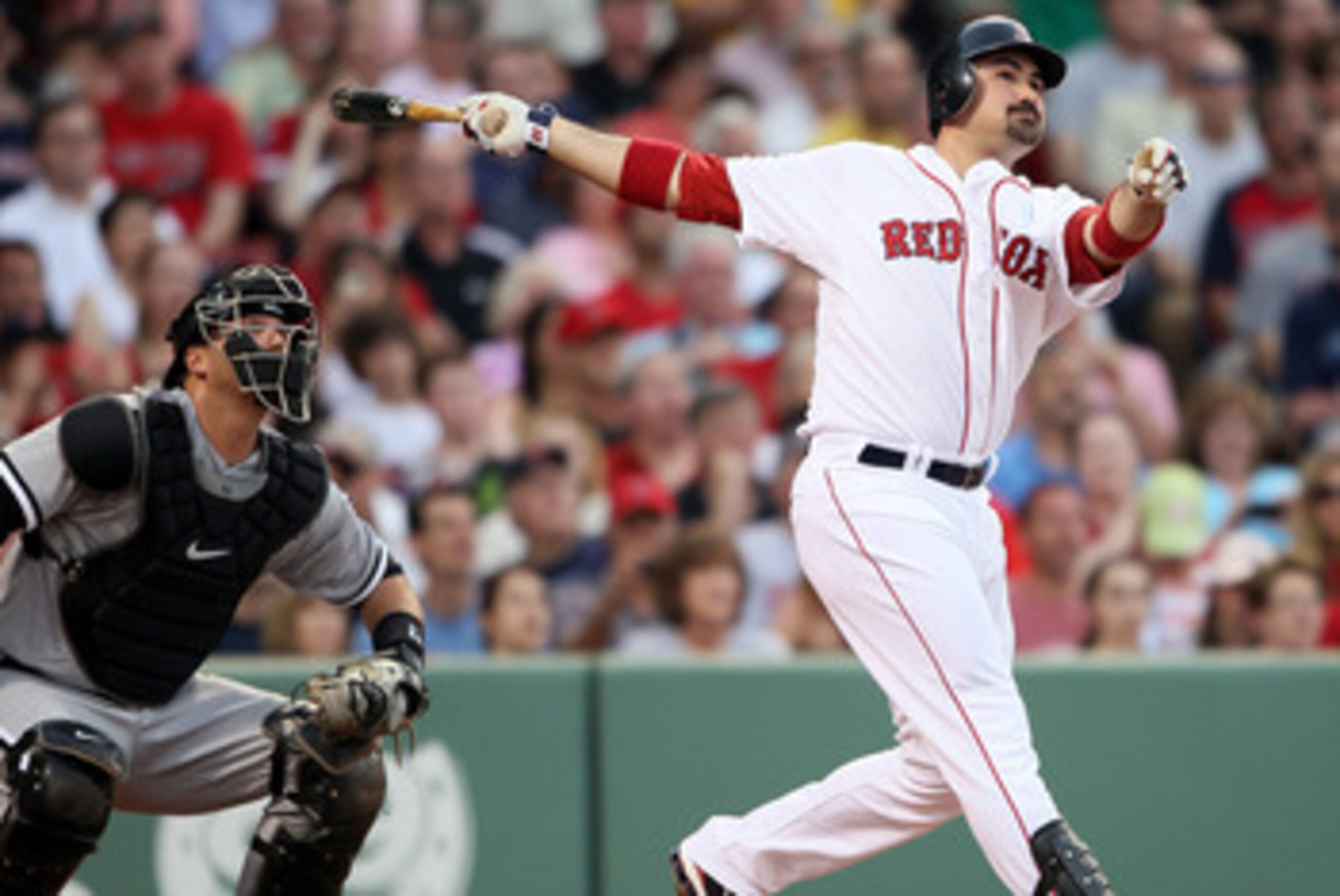 BOSTON, MA - MAY 30:  Adrian Gonzalez #28 of the Boston Red Sox hits a solo home run in the first inning as A.J. Pierzynski #12 of the Chicago White Sox catches on May 30, 2011 at Fenway Park in Boston, Massachusetts.  (Photo by Elsa/Getty Images)
