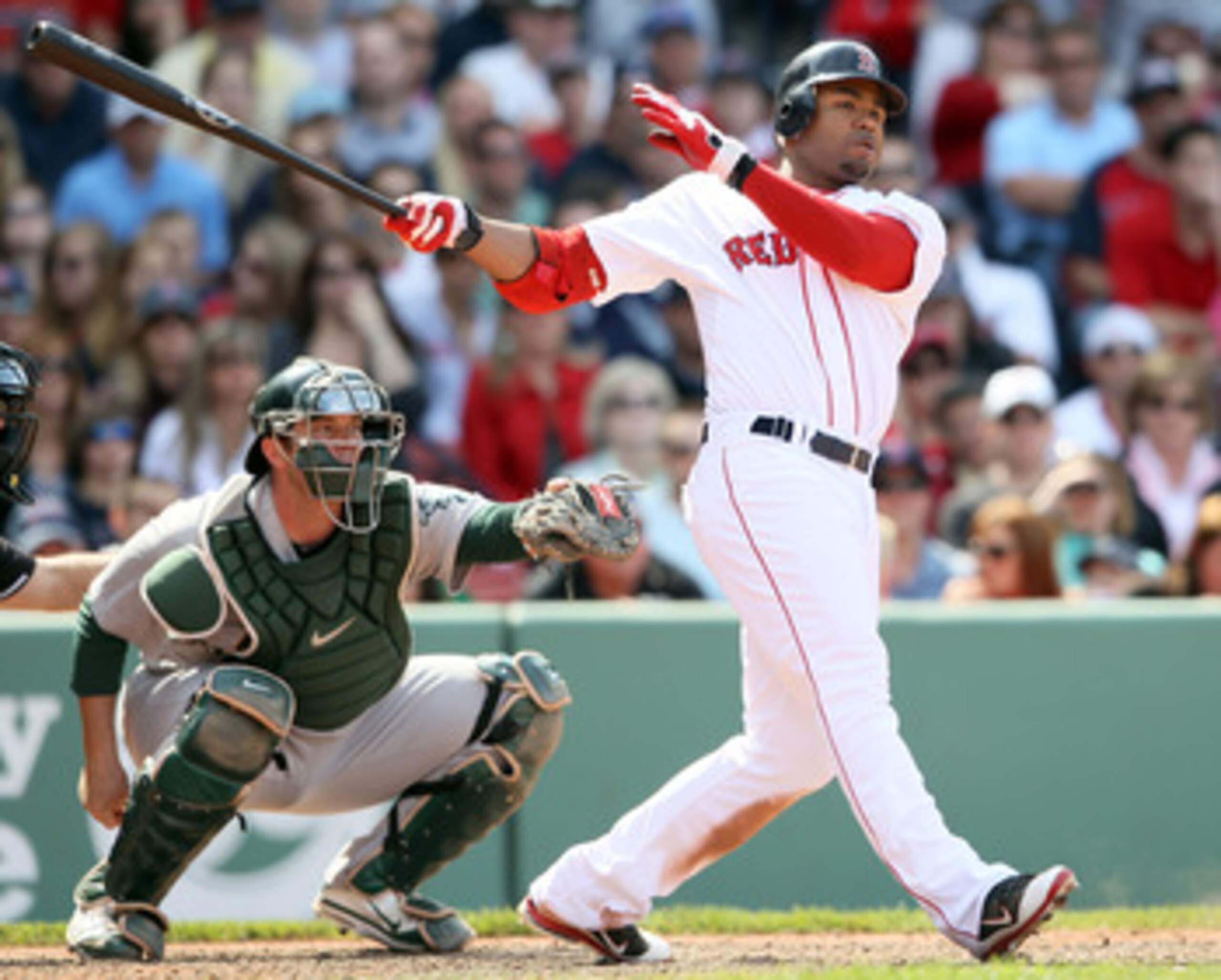 BOSTON, MA - JUNE 04:  Carl Crawford #13 of the Boston Red Sox hits a 2 RBI double in the eighth inning as Landon Powell #11 of the Oakland Athletics catches on June 4, 2011 at Fenway Park in Boston, Massachusetts.  (Photo by Elsa/Getty Images)