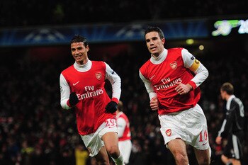 LONDON, ENGLAND - DECEMBER 08:  Robin van Persie of Arsenal celebrates with Marouane Chamakh (L) as he scores their first goal from the penalty spot during the UEFA Champions League Group H match between Arsenal and FK Partizan Belgrade at the Emirates St