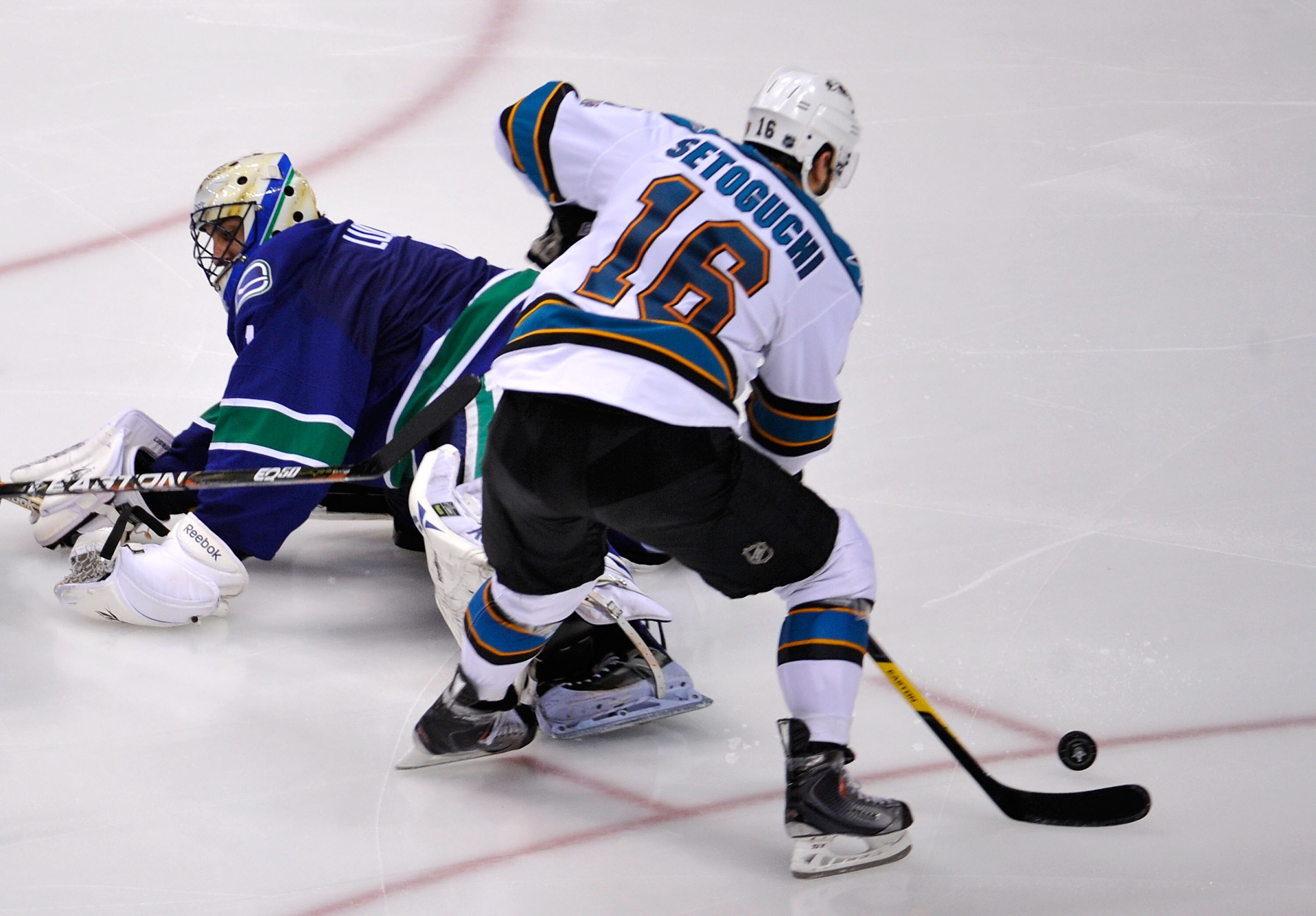 VANCOUVER, CANADA - MAY 24:  Devin Setoguchi #16 of the San Jose Sharks plays the puck past goaltender Roberto Luongo #1 of the Vancouver Canucks and goes on to score into an empty net in the third period  in Game Five of the Western Conference Finals dur