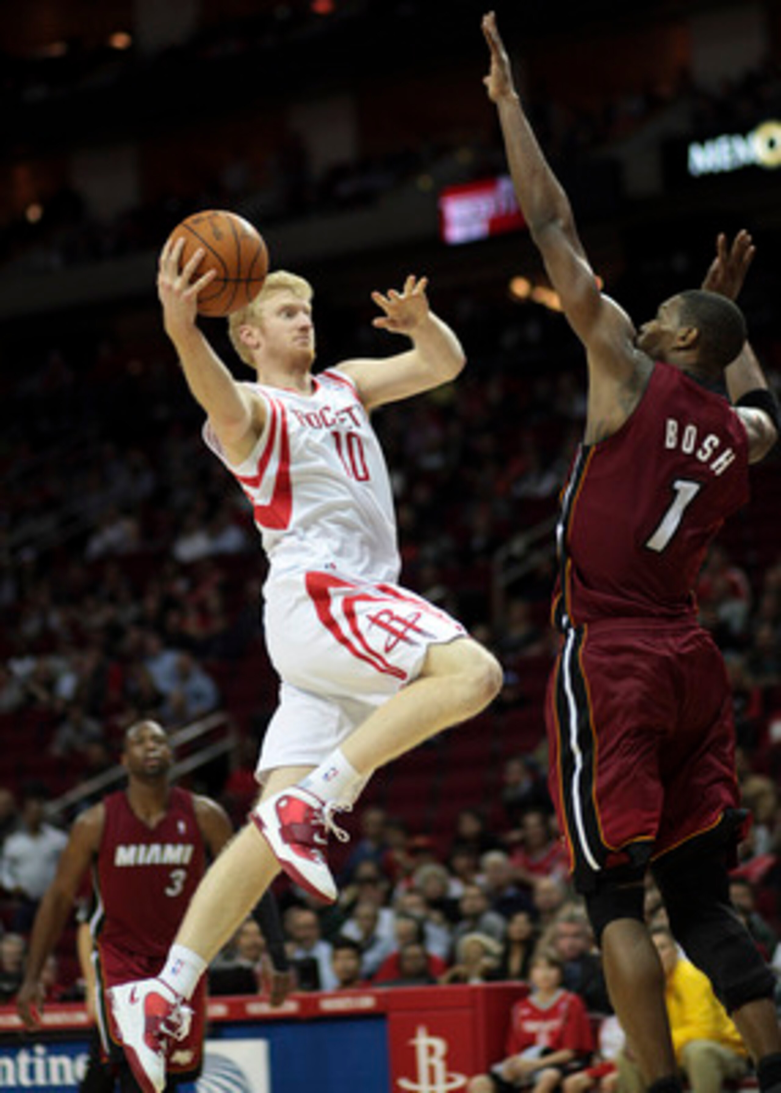 HOUSTON - DECEMBER 29: Chase Budinger #10 of the Houston Rockets drives the basket over Chris Bosh #1 of the Miami Heat in the second half at Toyota Center on December 29, 2010 in Houston, Texas. Miami won 125-119. NOTE TO USER: User expressly acknowledge