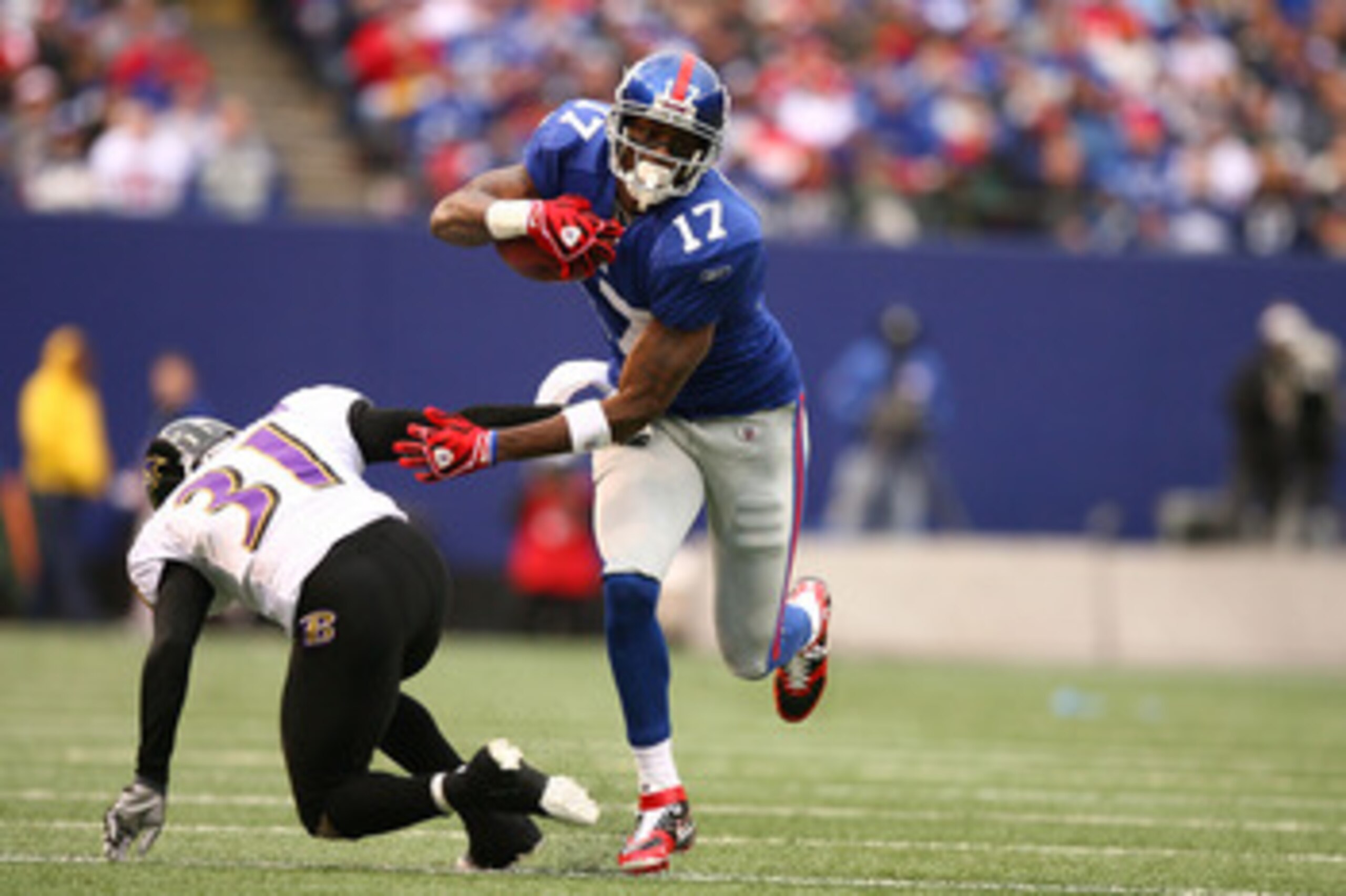EAST RUTHERFORD, NJ - NOVEMBER 16:  Plaxico Burress #17 of the New York Giants eludes the tackle of Fabian Washington #31 of the Baltimore Ravens during their game on November 16, 2008 at Giants Stadium in East Rutherford, New Jersey.  (Photo by Al Bello/