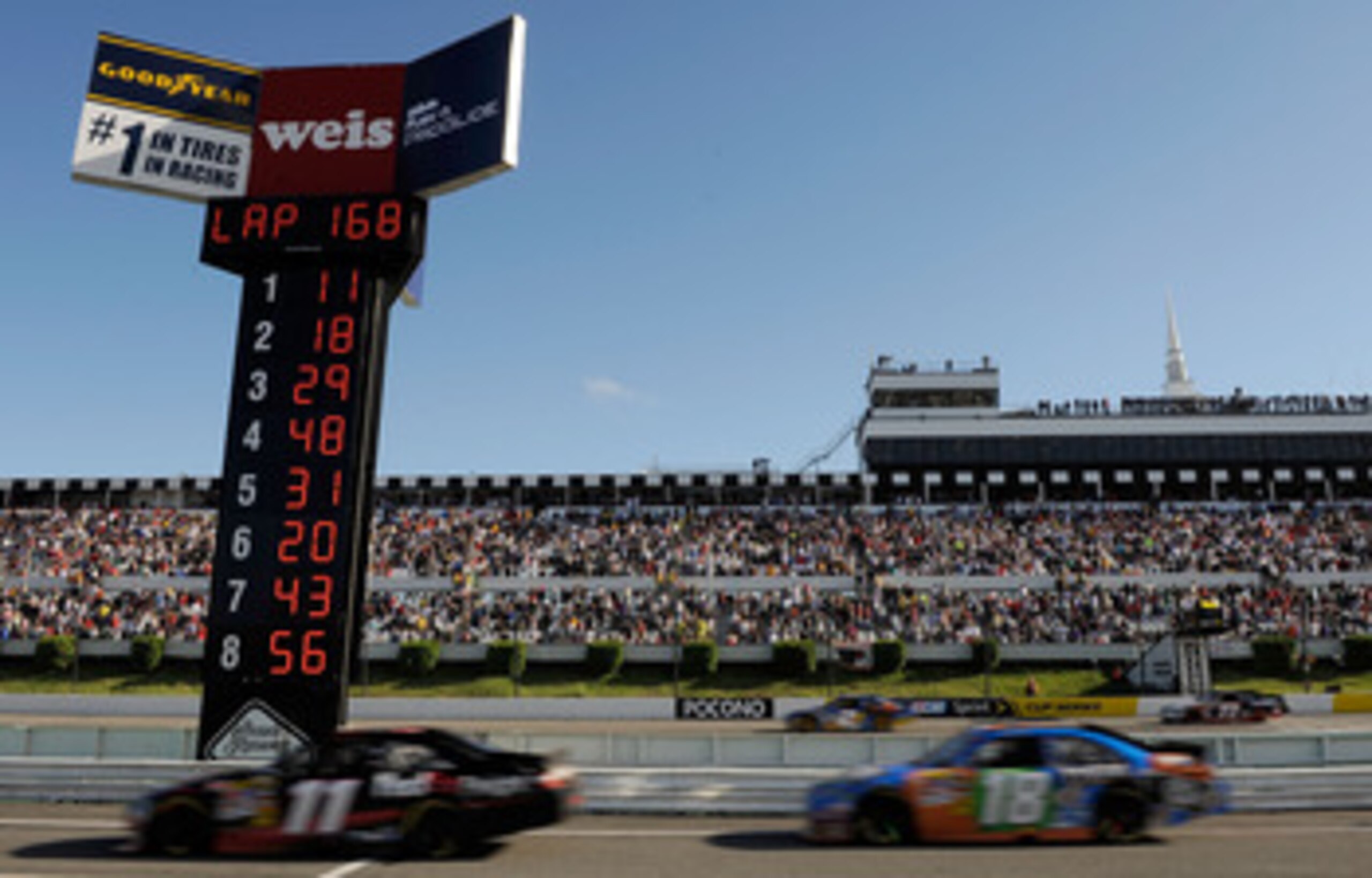 LONG POND, PA - JUNE 06:  Denny Hamlin, driver of the #11 FedEx Freight Toyota leads Kyle Busch, driver of the #18 M&M's Toyota, down pit road for his final pit stop during the NASCAR Sprint Cup Series Gillette Fusion ProGlide 500 at Pocono Raceway on Jun