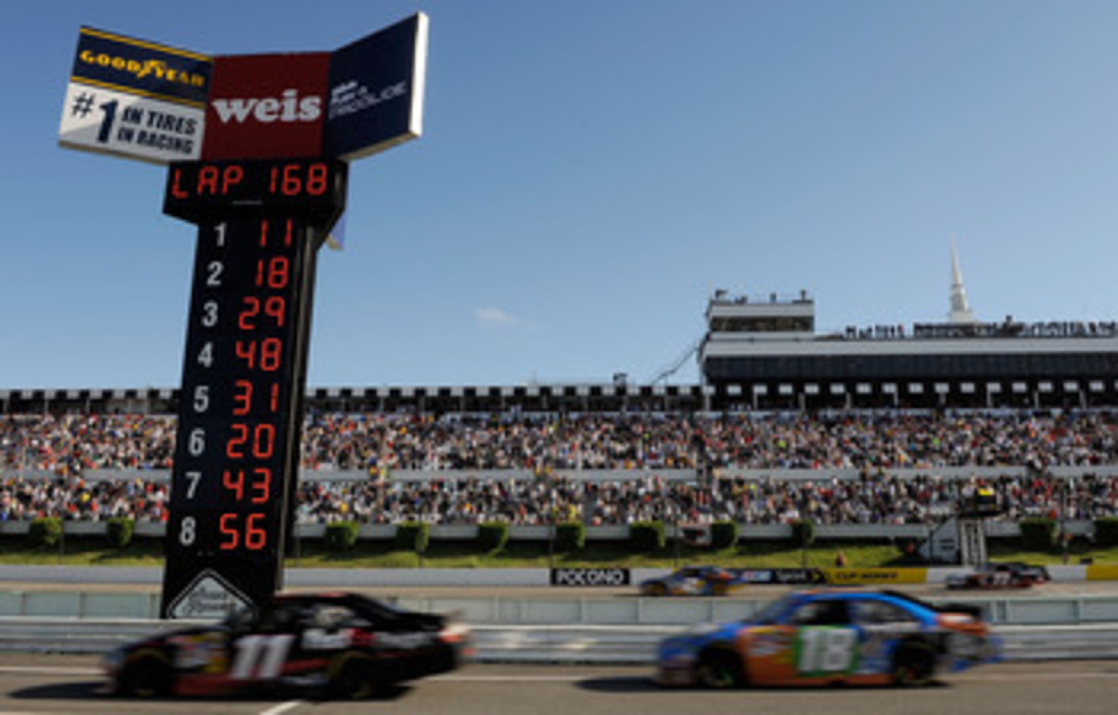 LONG POND, PA - JUNE 06:  Denny Hamlin, driver of the #11 FedEx Freight Toyota leads Kyle Busch, driver of the #18 M&M's Toyota, down pit road for his final pit stop during the NASCAR Sprint Cup Series Gillette Fusion ProGlide 500 at Pocono Raceway on Jun