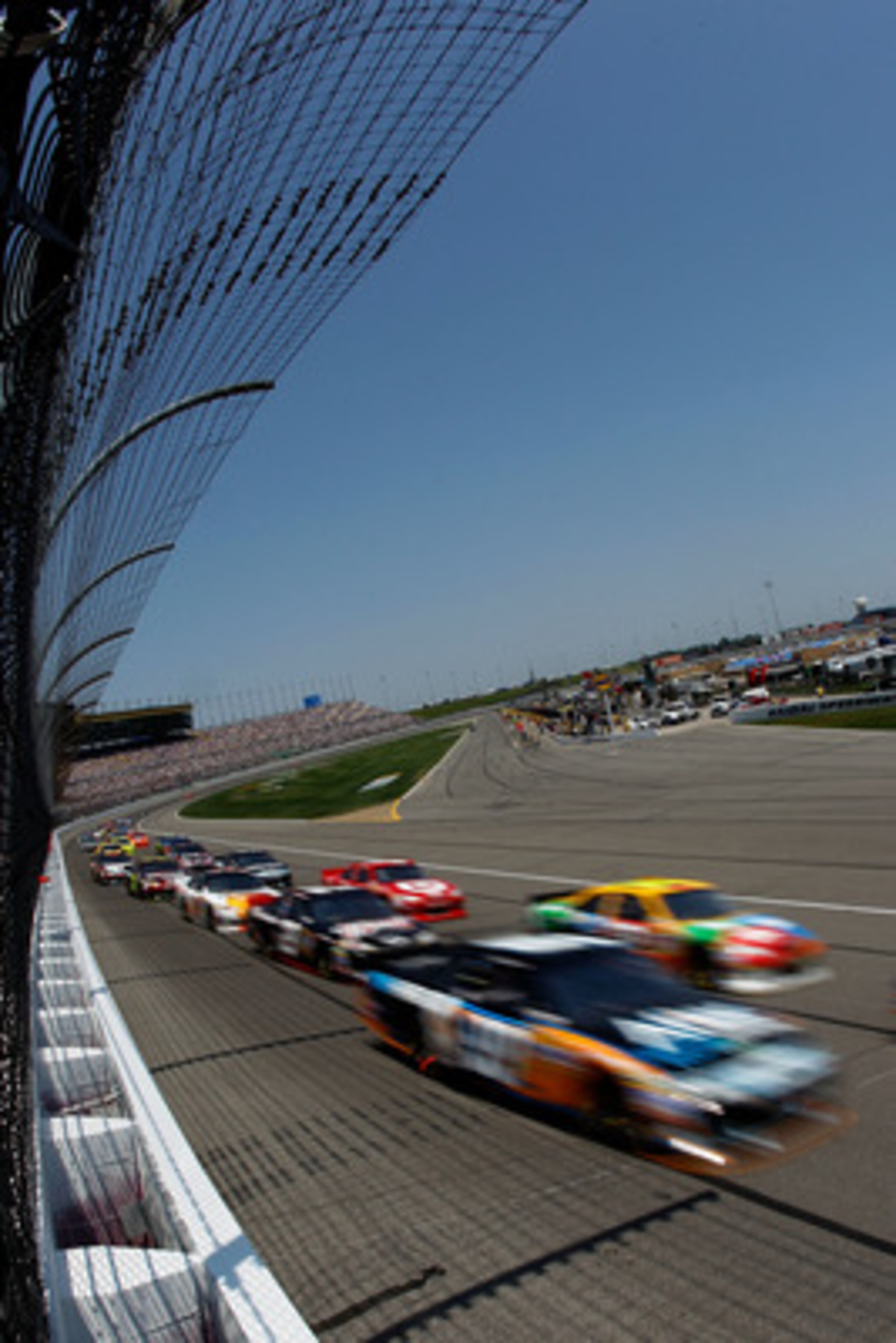 KANSAS CITY, KS - JUNE 05:  Carl Edwards, driver of the #99 Aflac Ford, and Kyle Busch, driver of the #18 M&M's Toyota, lead a group of cars during the NASCAR Sprint Cup Series STP 400 at Kansas Speedway on June 5, 2011 in Kansas City, Kansas.  (Photo by 