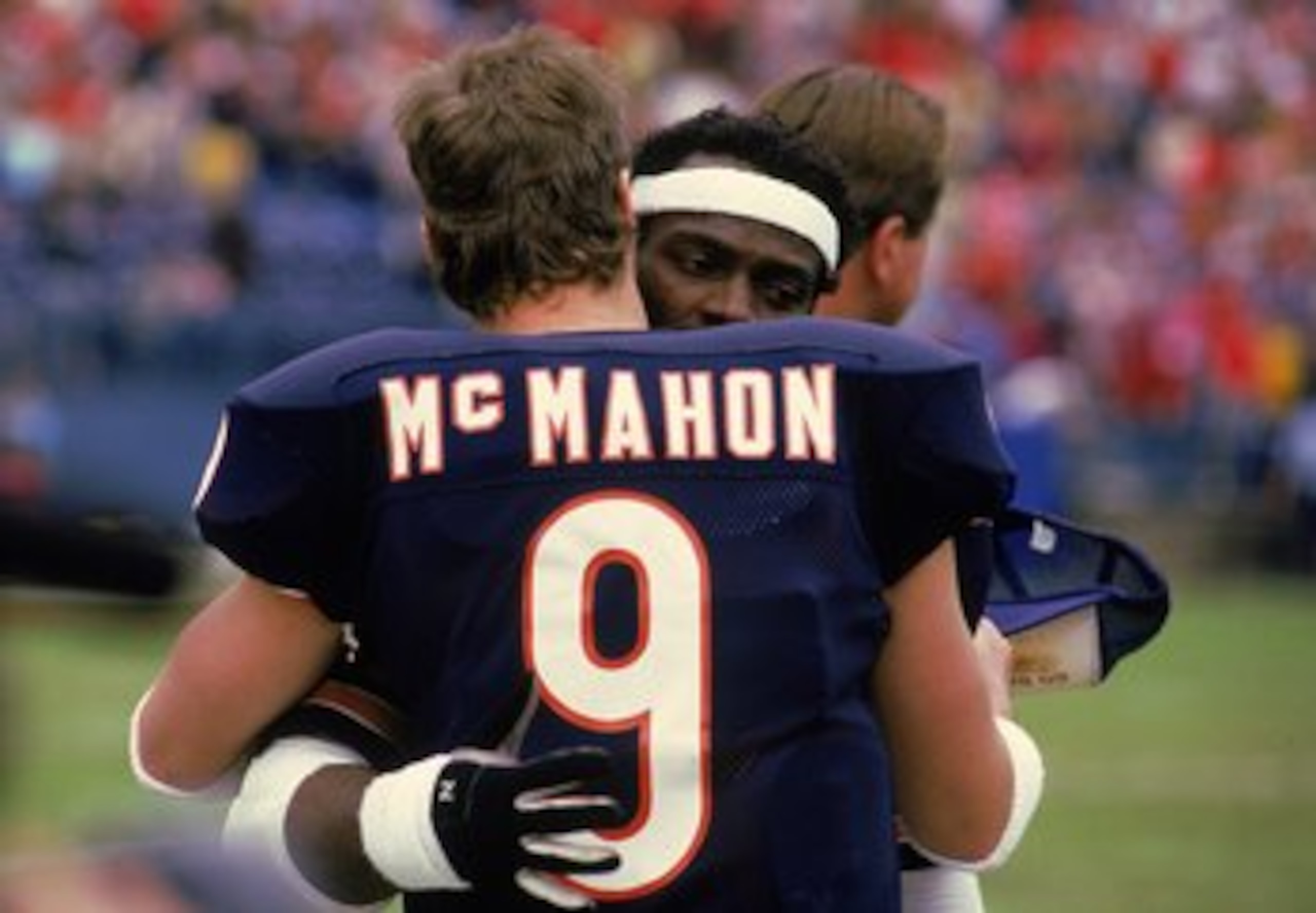 Walter Payton #34 of the Chicago Bears hugs Quarterback Jim McMahon #9 after a game.