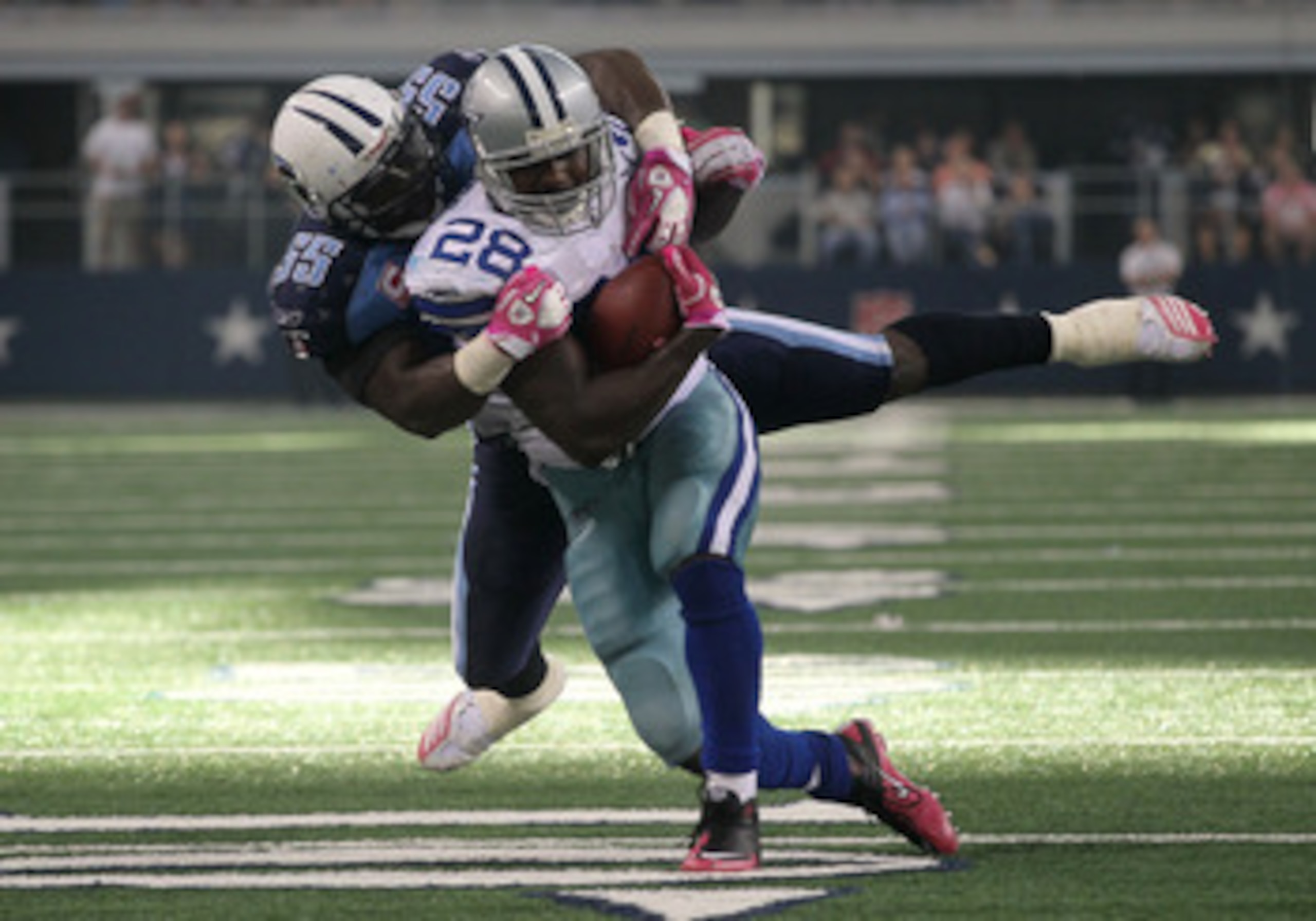 ARLINGTON, TX - OCTOBER 10:  Running back Felix Jones #28 of the Dallas Cowboys is tackled by linebacker Stephen Tulloch #55 of the Tennessee Titans at Cowboys Stadium on October 10, 2010 in Arlington, Texas. The Titans won 34-27.  (Photo by Stephen Dunn/