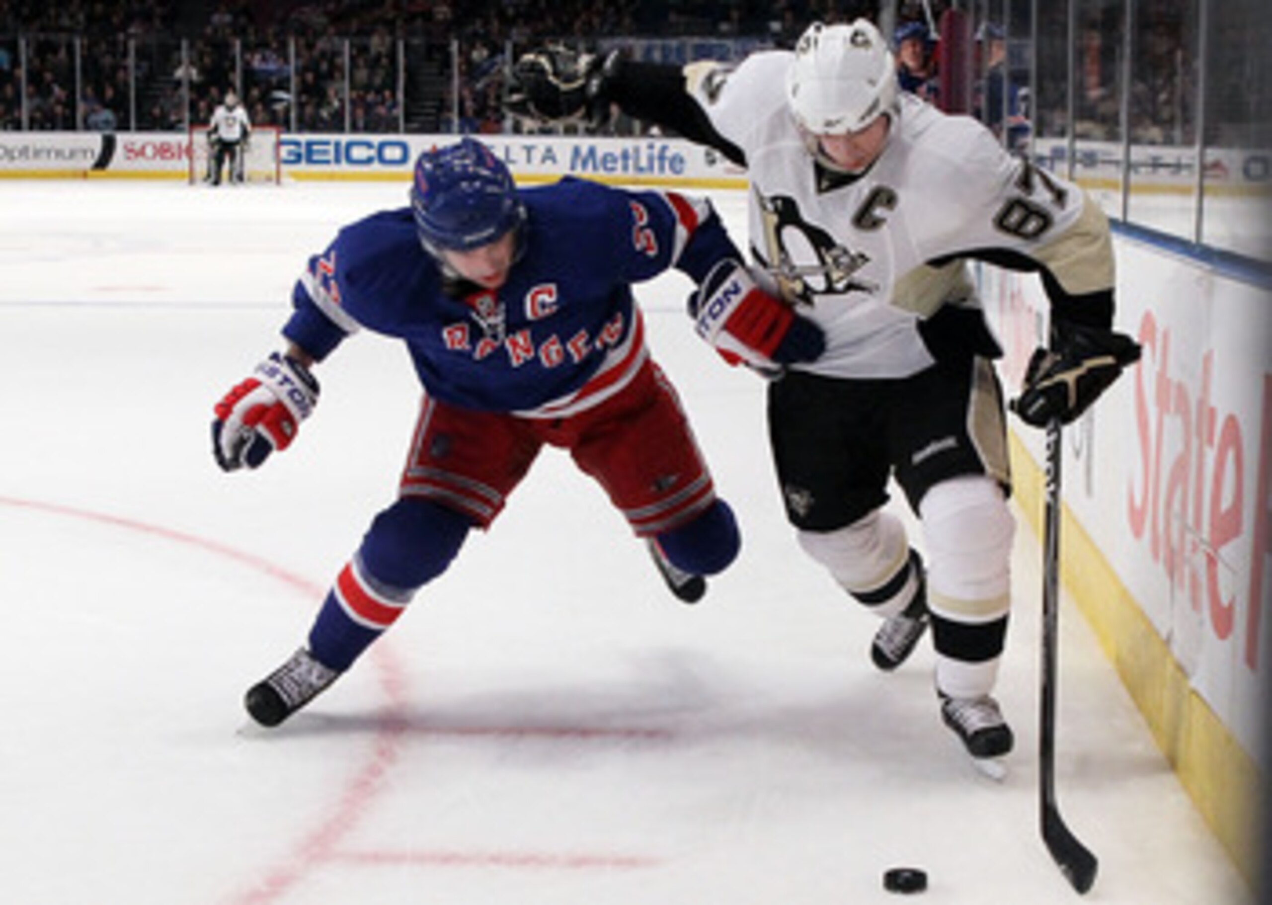 NEW YORK - MARCH 04:  Sidney Crosby #87 of the Pittsburgh Penguins tries to control the puck against Chris Drury #23 of the New York Rangers on March 4, 2010 at Madison Square Garden in New York City. The Penguins defeated the Rangers 5-4 in overtime.  (P
