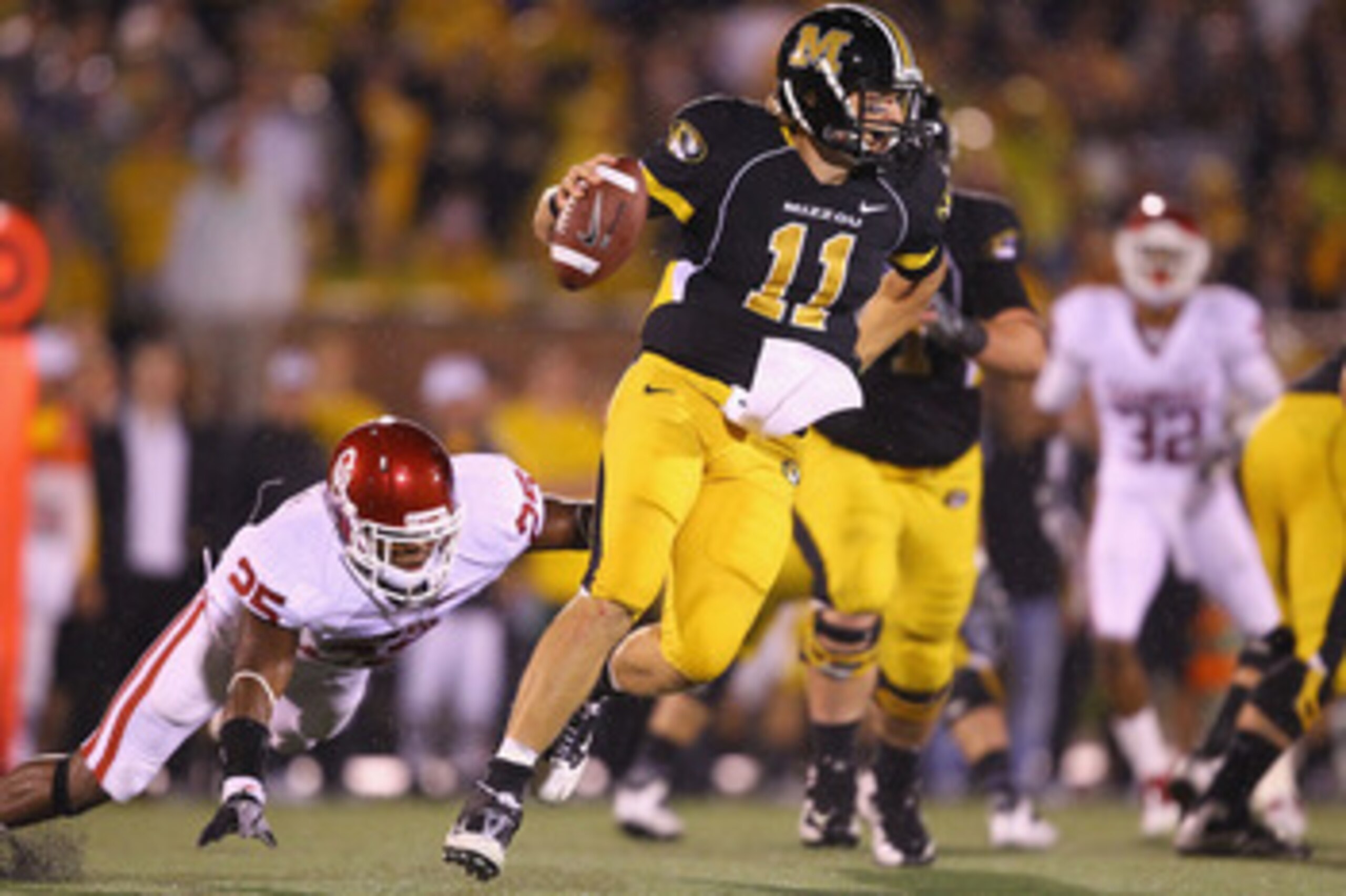 COLUMBIA, MISSOURI - OCTOBER 23: Blaine Gabbert #11 of the Missouri Tigers looks to get away from Emmanuel Jones #25 of the Oklahoma Sooners at Faurot Field/Memorial Stadium on October 23, 2010 in Columbia, Missouri.  The Tigers beat the Sooners 36-27.  (