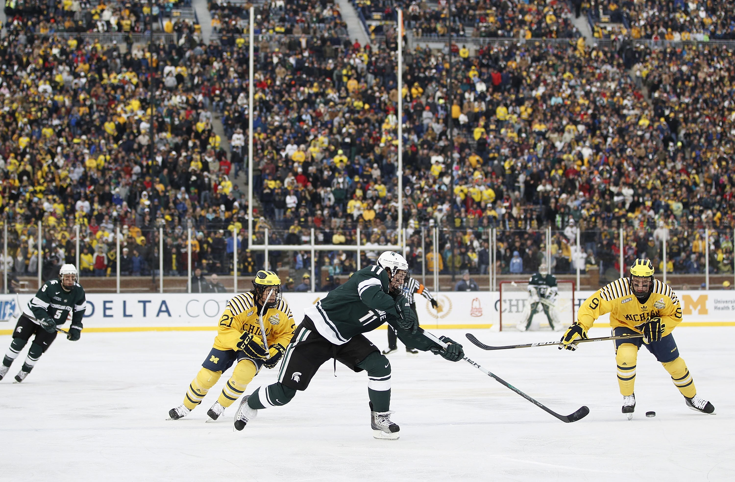 ANN ARBOR, MI - DECEMBER 11: Brett Perlini #11 of the Michigan State Spartans passes to a teamate in front of A.J. Treais #21 and Luke Moffatt #9 of the Michigan Wolverines at Michigan Stadium on December 11, 2010 in Ann Arbor, Michigan.  (Photo by Gregor