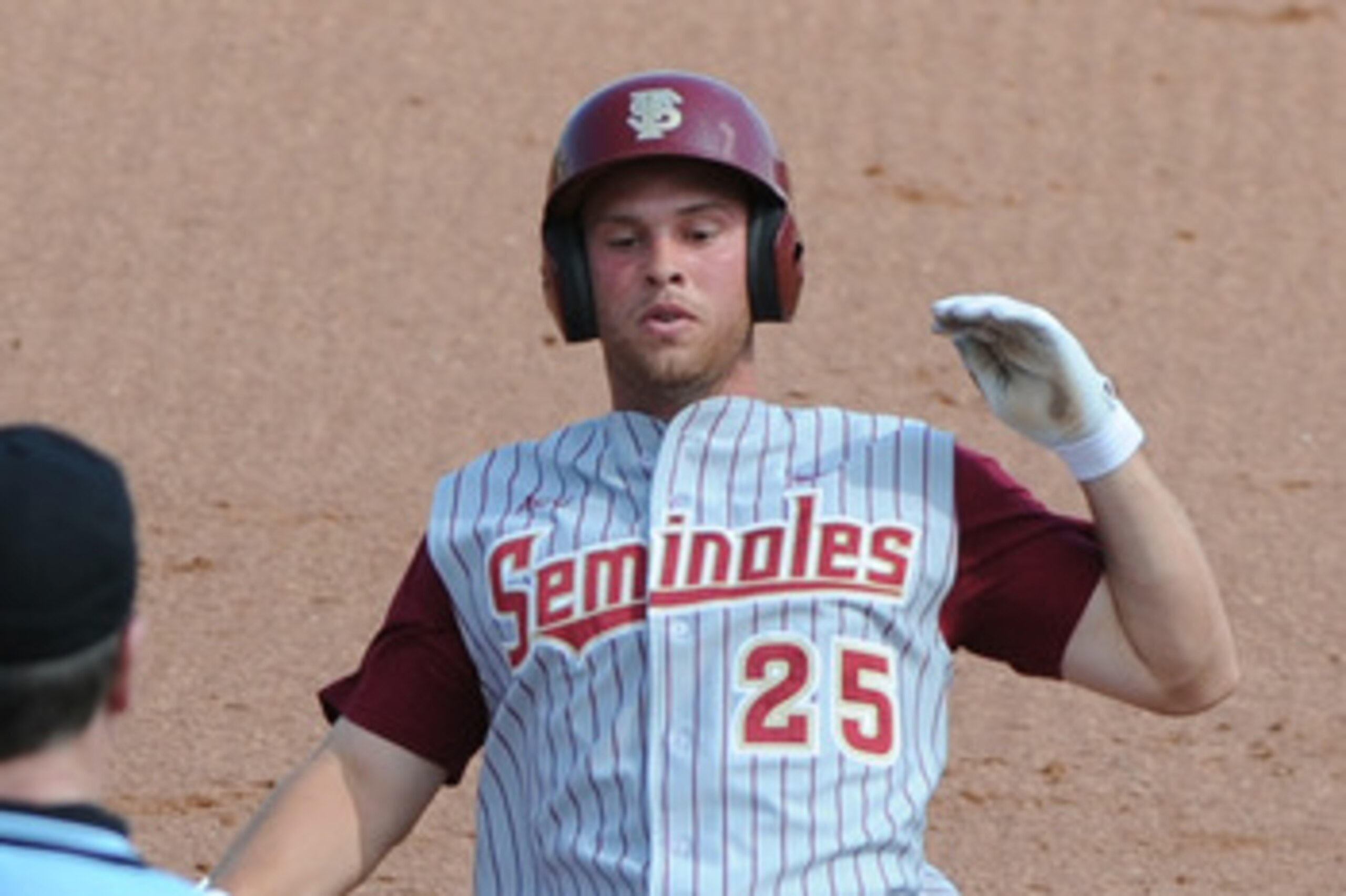 CLEARWATER, FL - FEBRUARY 24:  Outfielder Mike McGee #25 of  the Florida State Seminoles slides into third base against the Philadelphia Phillies February 24, 2011 at Bright House Field in Clearwater, Florida.  (Photo by Al Messerschmidt/Getty Images)