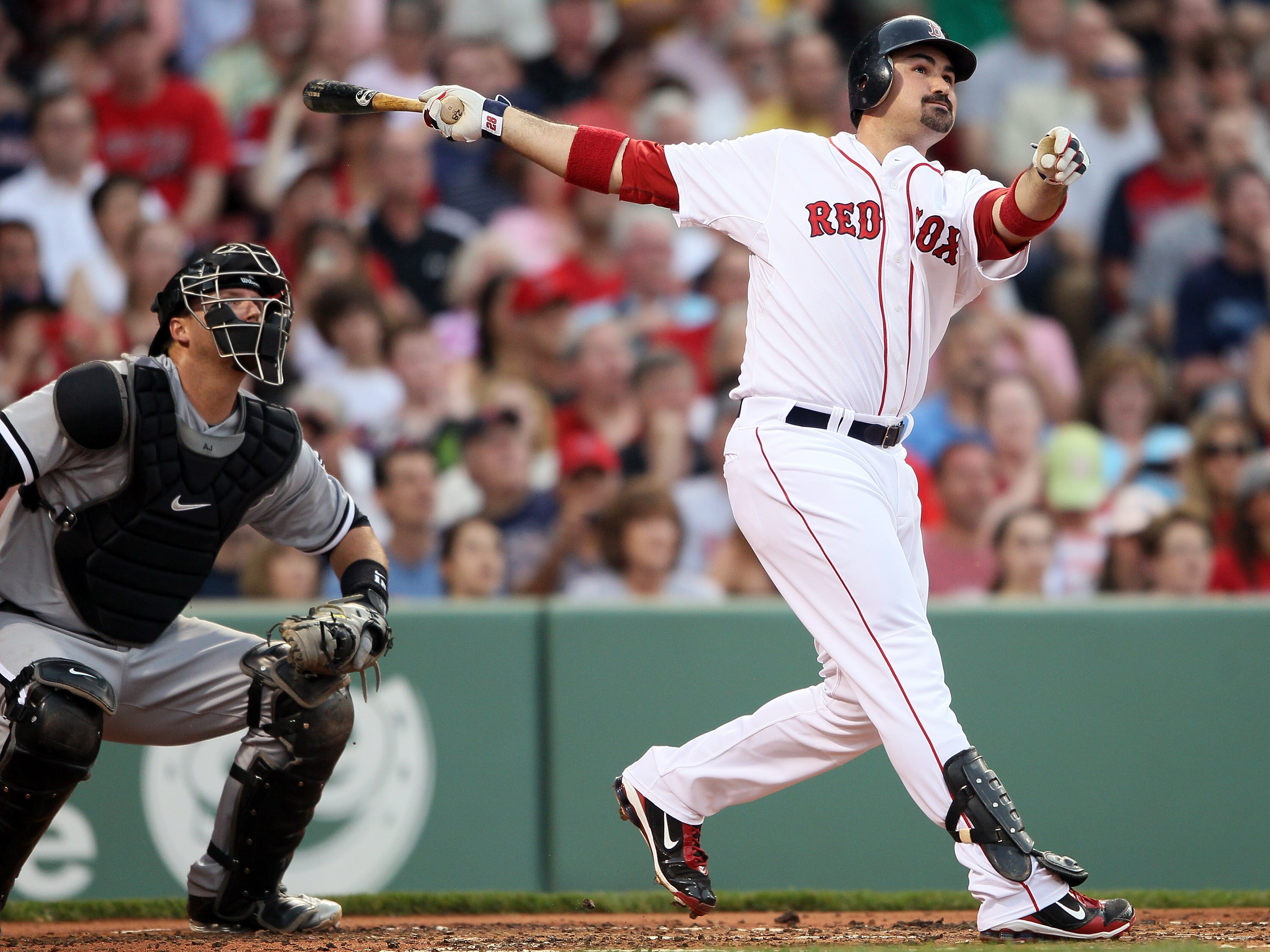 BOSTON, MA - MAY 30:  Adrian Gonzalez #28 of the Boston Red Sox hits a solo home run in the first inning as A.J. Pierzynski #12 of the Chicago White Sox catches on May 30, 2011 at Fenway Park in Boston, Massachusetts.  (Photo by Elsa/Getty Images)