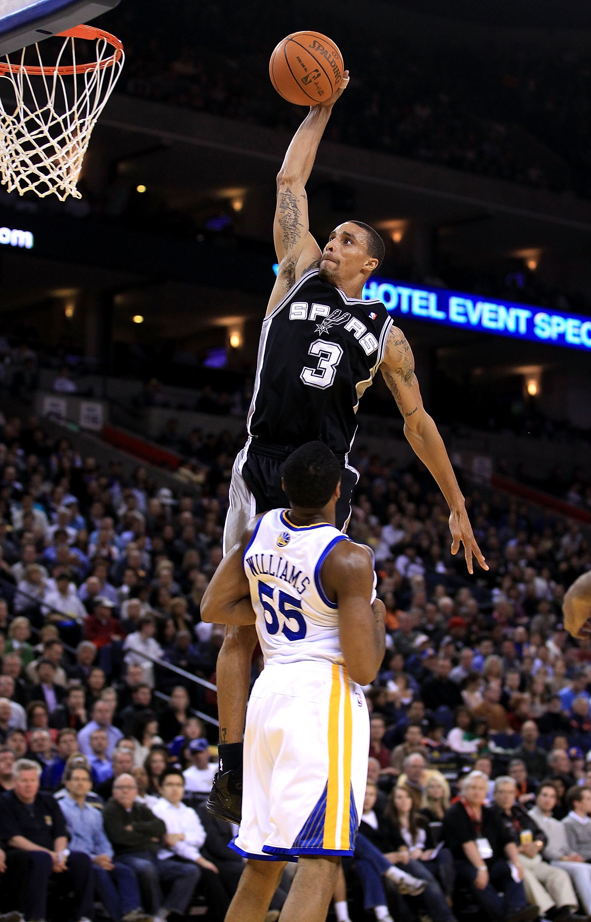OAKLAND, CA - JANUARY 24:  George Hill #3 of the San Antonio Spurs goes up for a dunk over Reggie Williams #55 of the Golden State Warriors at Oracle Arena on January 24, 2011 in Oakland, California.  NOTE TO USER: User expressly acknowledges and agrees t