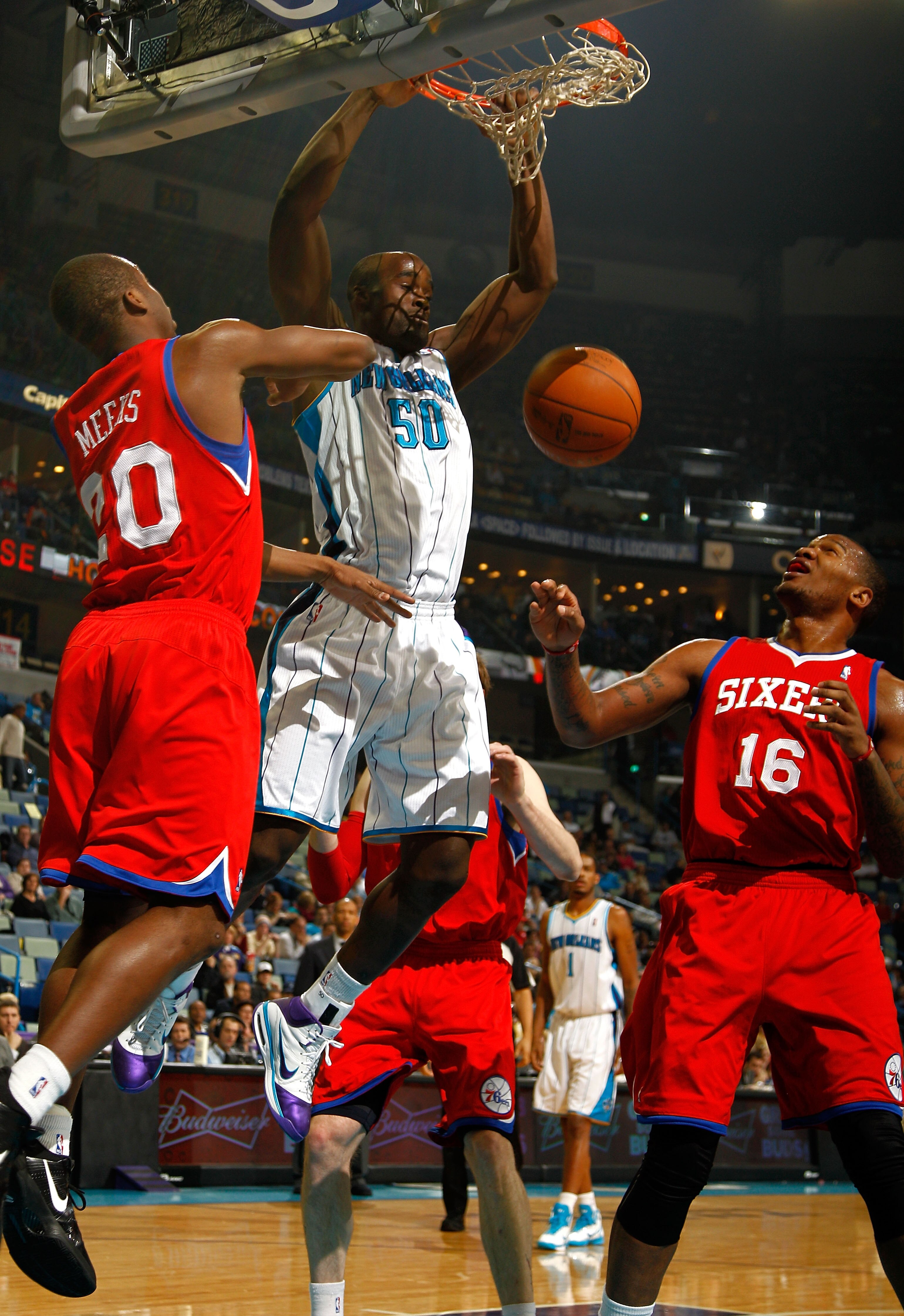 NEW ORLEANS, LA - JANUARY 03:  Emeka Okafor #50 of the New Orleans Hornets dunks the ball between Jodie Meeks #20 and Marreese Speights #16 of the Philadelphia 76ers in the first half at New Orleans Arena on January 3, 2011 in New Orleans, Louisiana. NOTE