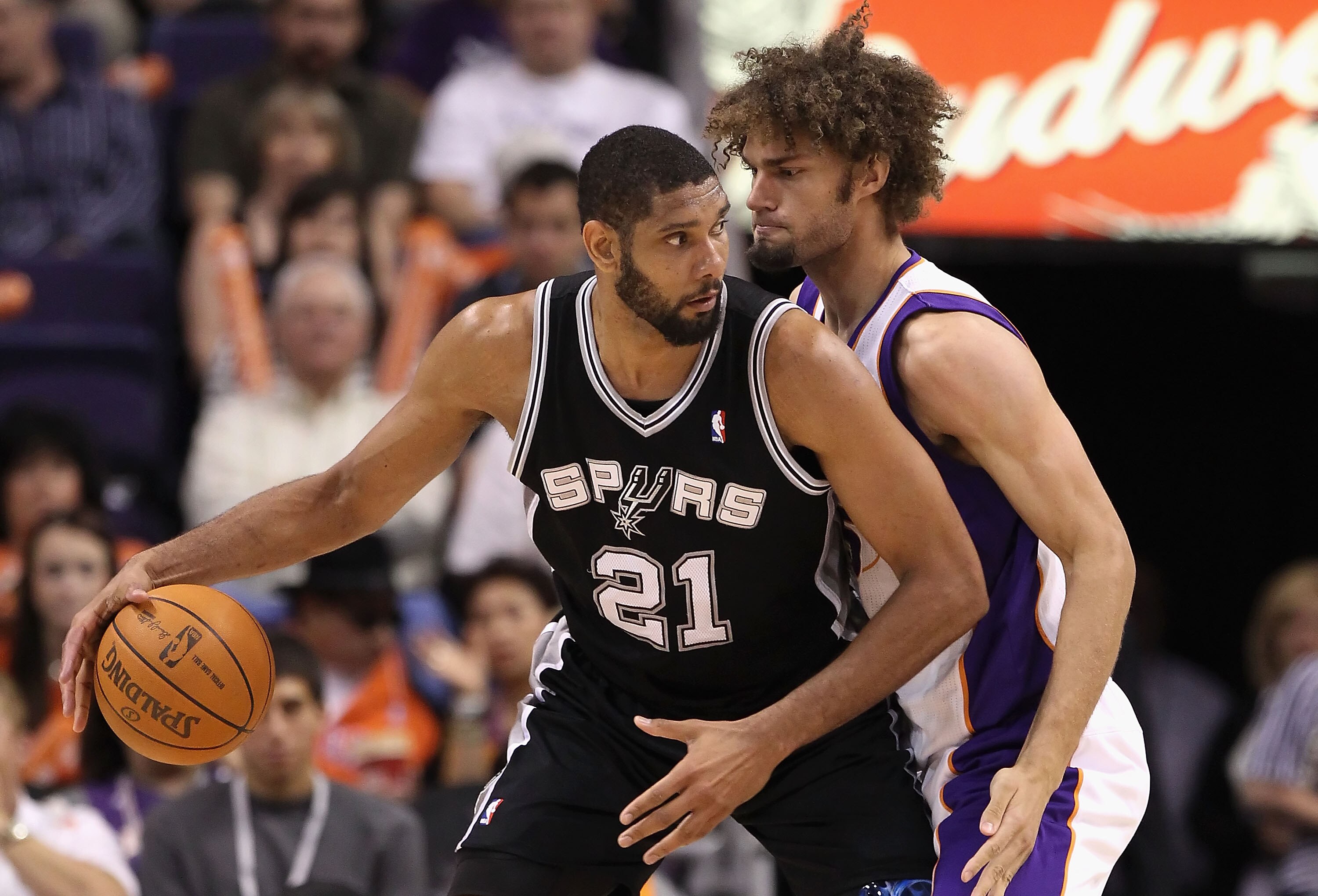 PHOENIX, AZ - APRIL 13:  Tim Duncan #21 of the San Antonio Spurs handles the ball under pressure from Robin Lopez #15 of the Phoenix Suns during the NBA game at US Airways Center on April 13, 2011 in Phoenix, Arizona.  NOTE TO USER: User expressly acknowl