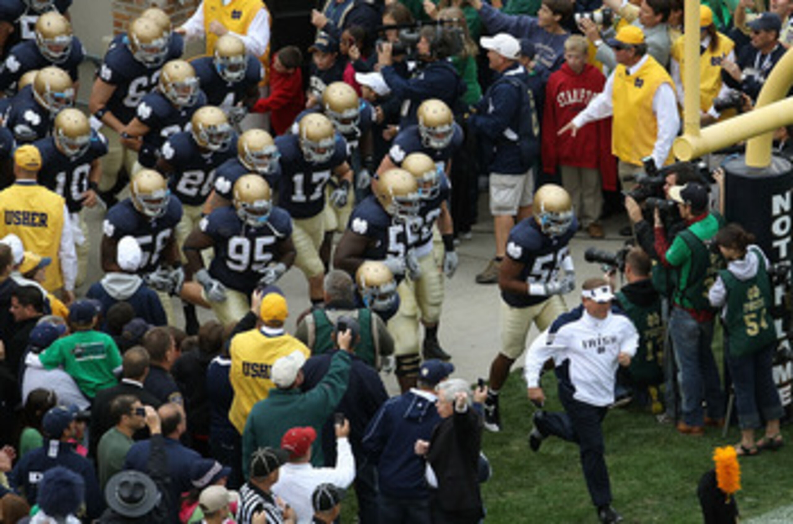 SOUTH BEND, IN - SEPTEMBER 25: Head coach Brian Kelly of the Notre Dame Fighting Irish leads his team onto the field before taking on the Stanford Cardinal at Notre Dame Stadium on September 25, 2010 in South Bend, Indiana. Stanford defeated Notre Dame 37
